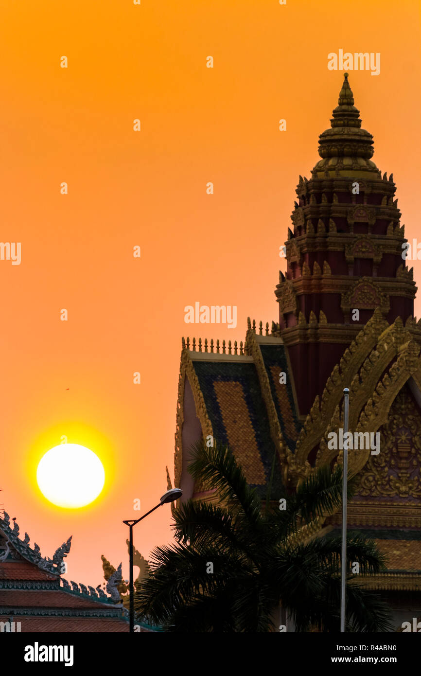 Sunset silhouette di Wat Ounalom monastero & tempio sul lungofiume. Preah Sisowath Quay, centro della città di Phnom Penh, Cambogia Foto Stock