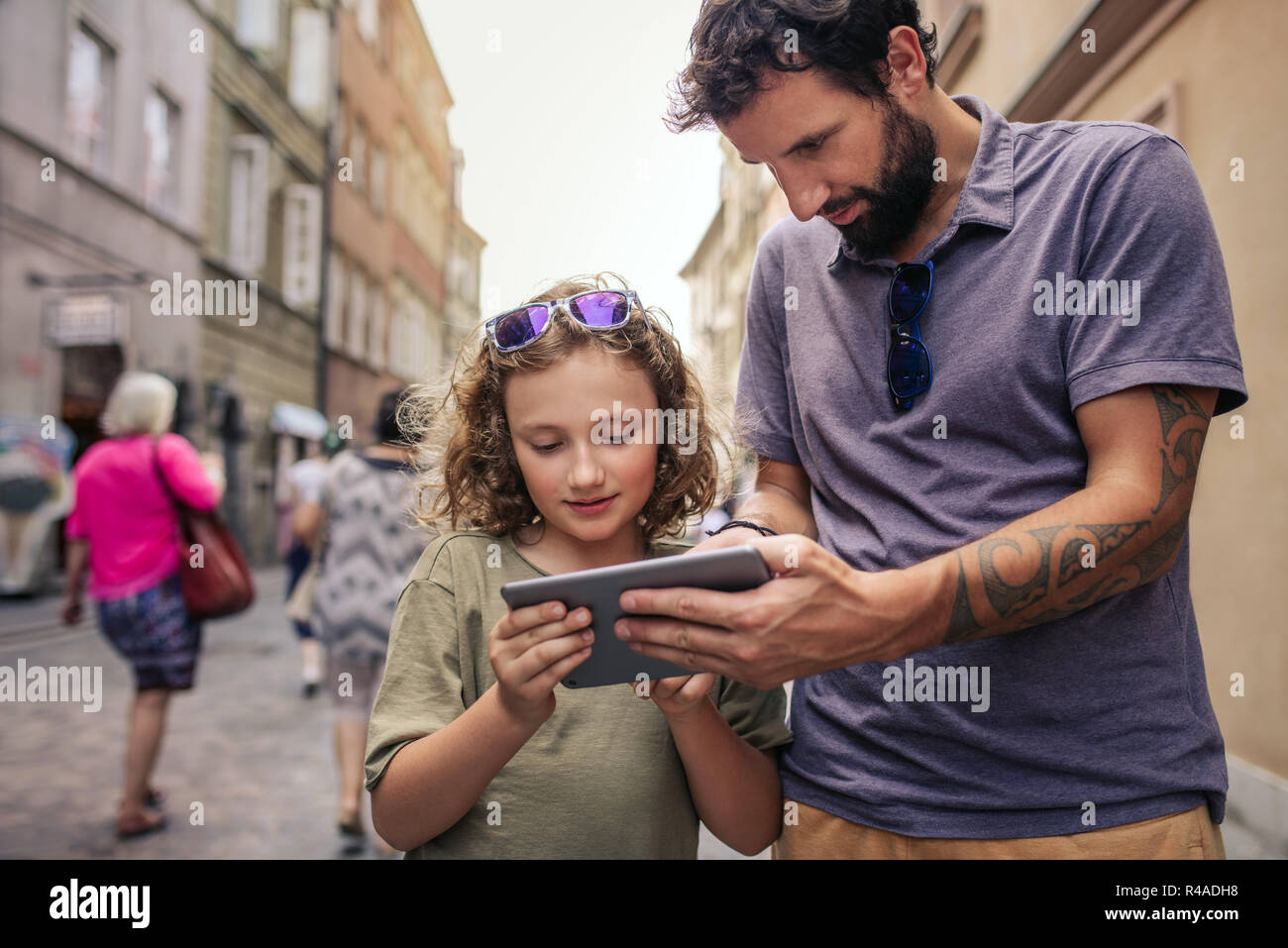 Padre e figlio di esplorare la città con una tavoletta digitale Foto Stock