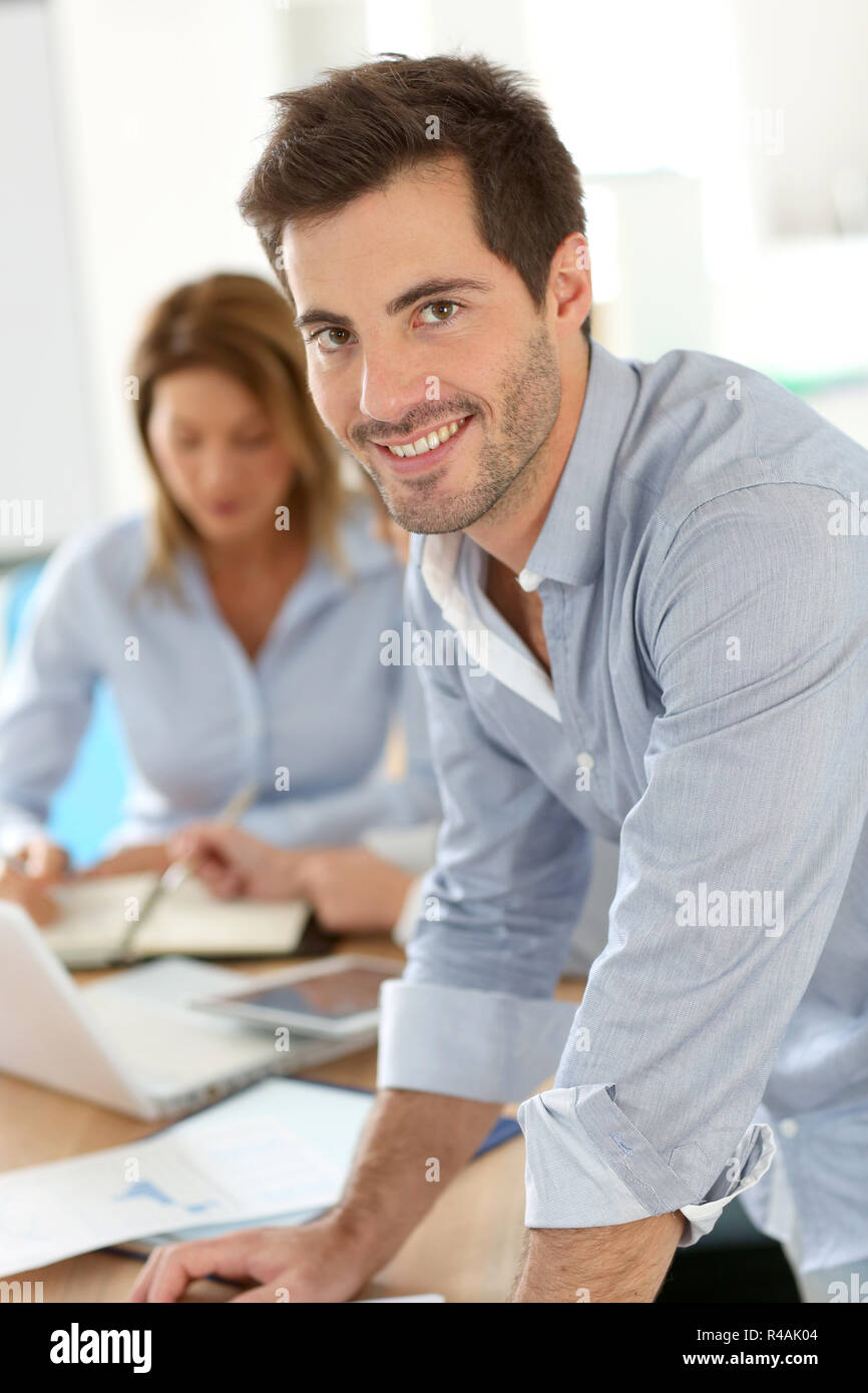 Imprenditore sorridente che frequentano riunioni di lavoro Foto Stock