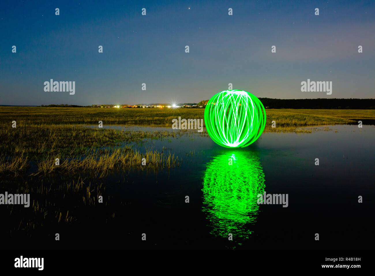 Futuristico sfera incandescente riflessa sulla superficie del fiume Foto Stock