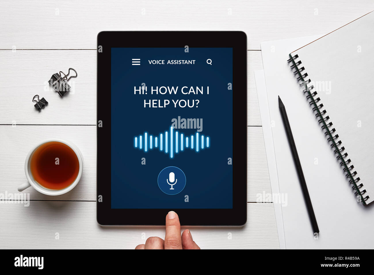 Assistente vocale concetto su tablet schermo con oggetti di Office su bianco tavolo in legno. Tutti i contenuti della schermata è progettato da me. Lay piatto Foto Stock