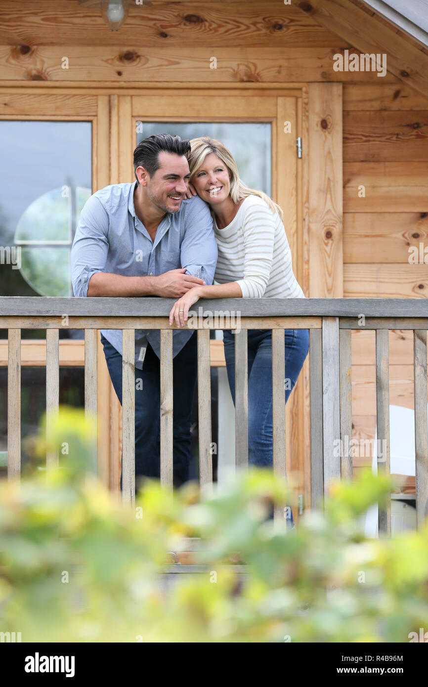 Matura in piedi in log cabin terrazza Foto Stock