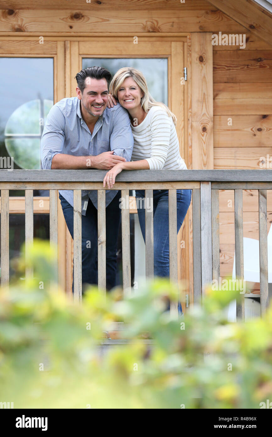 Matura in piedi in log cabin terrazza Foto Stock