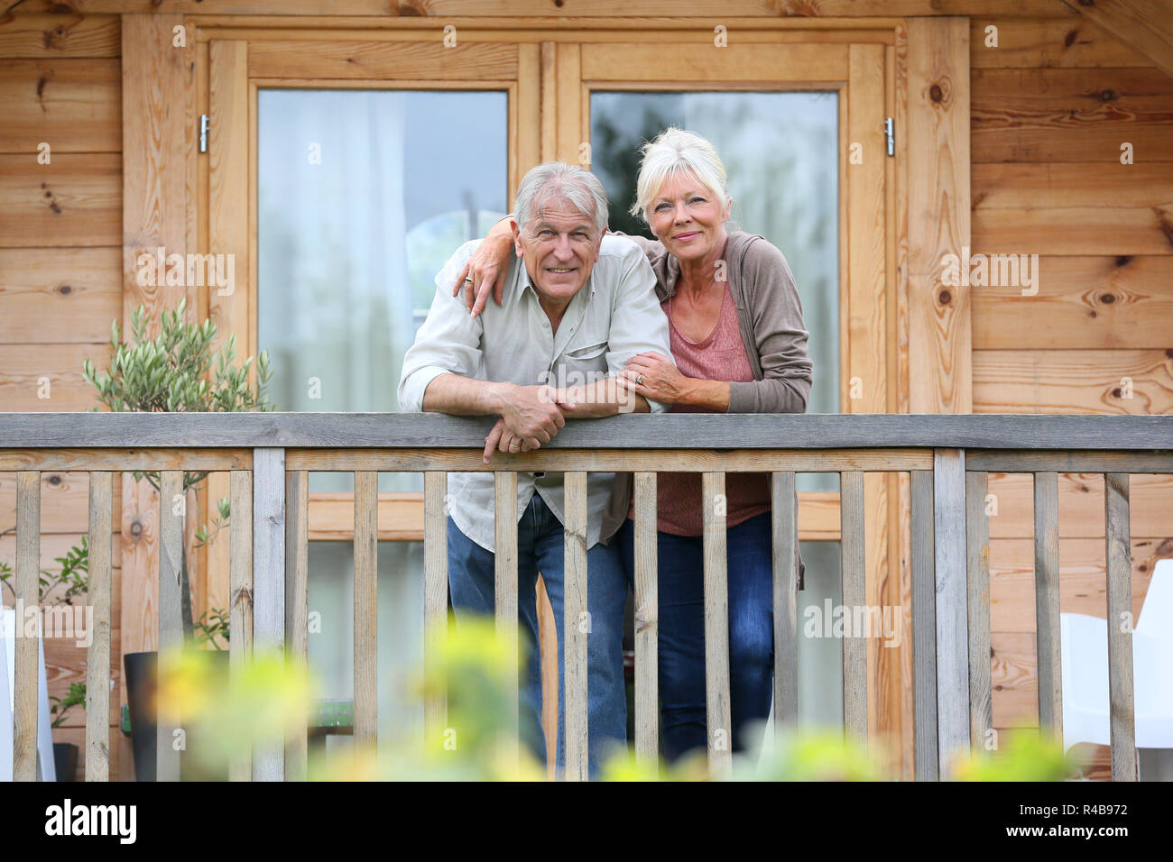 Coppia senior oustide permanente log cabin in campagna Foto Stock
