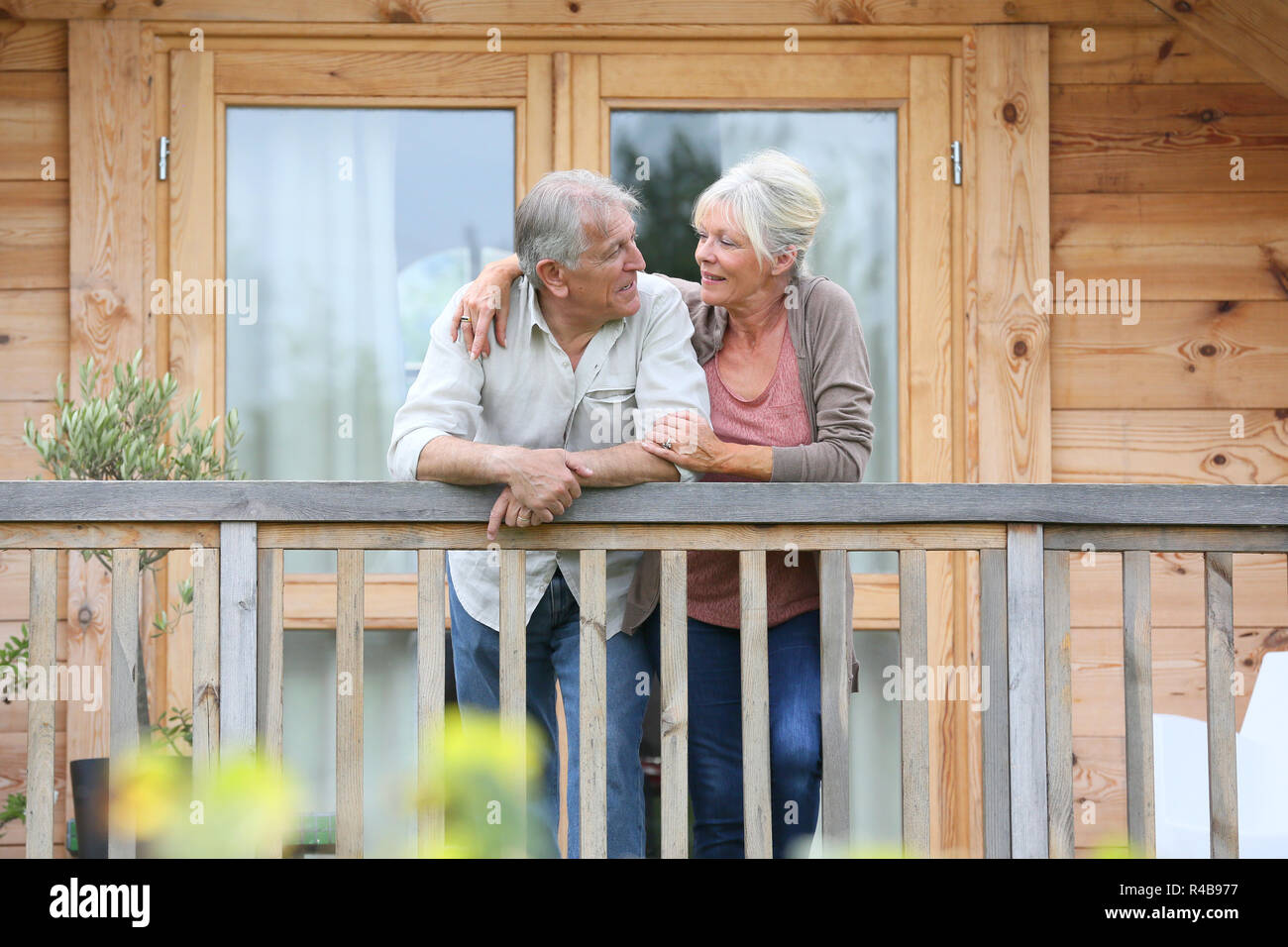 Coppia senior oustide permanente log cabin in campagna Foto Stock