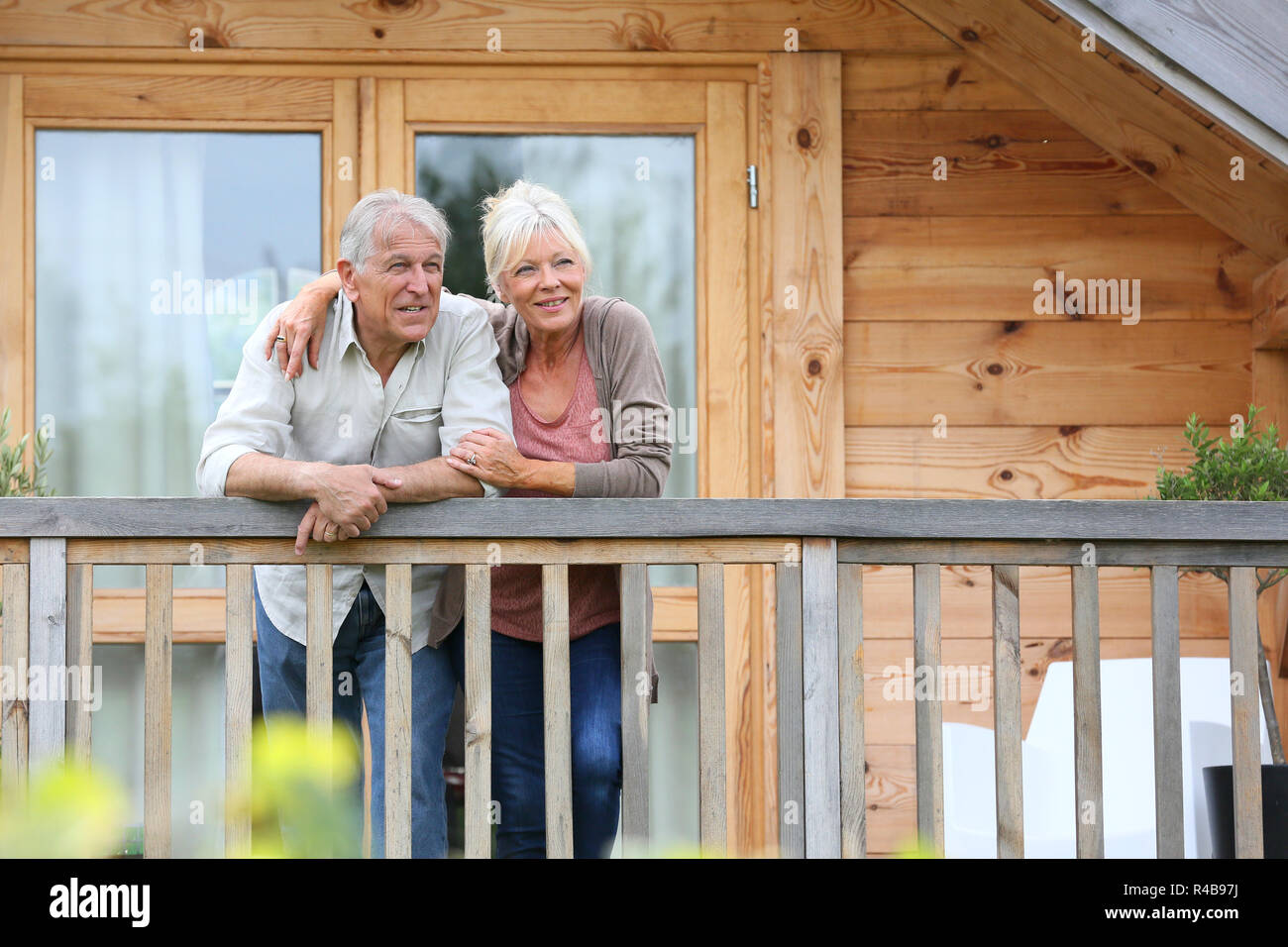 Coppia senior oustide permanente log cabin in campagna Foto Stock