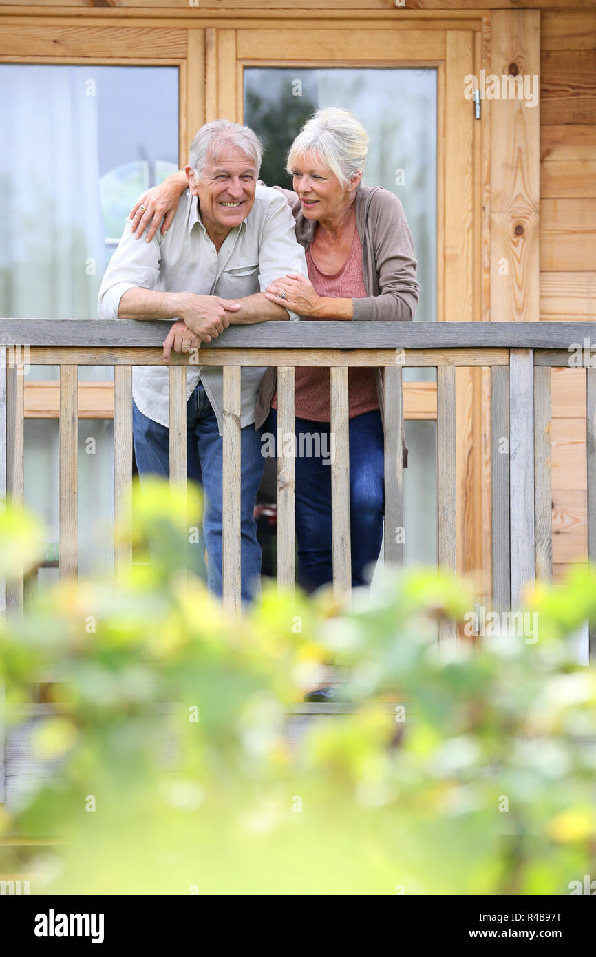 Coppia senior oustide permanente log cabin in campagna Foto Stock