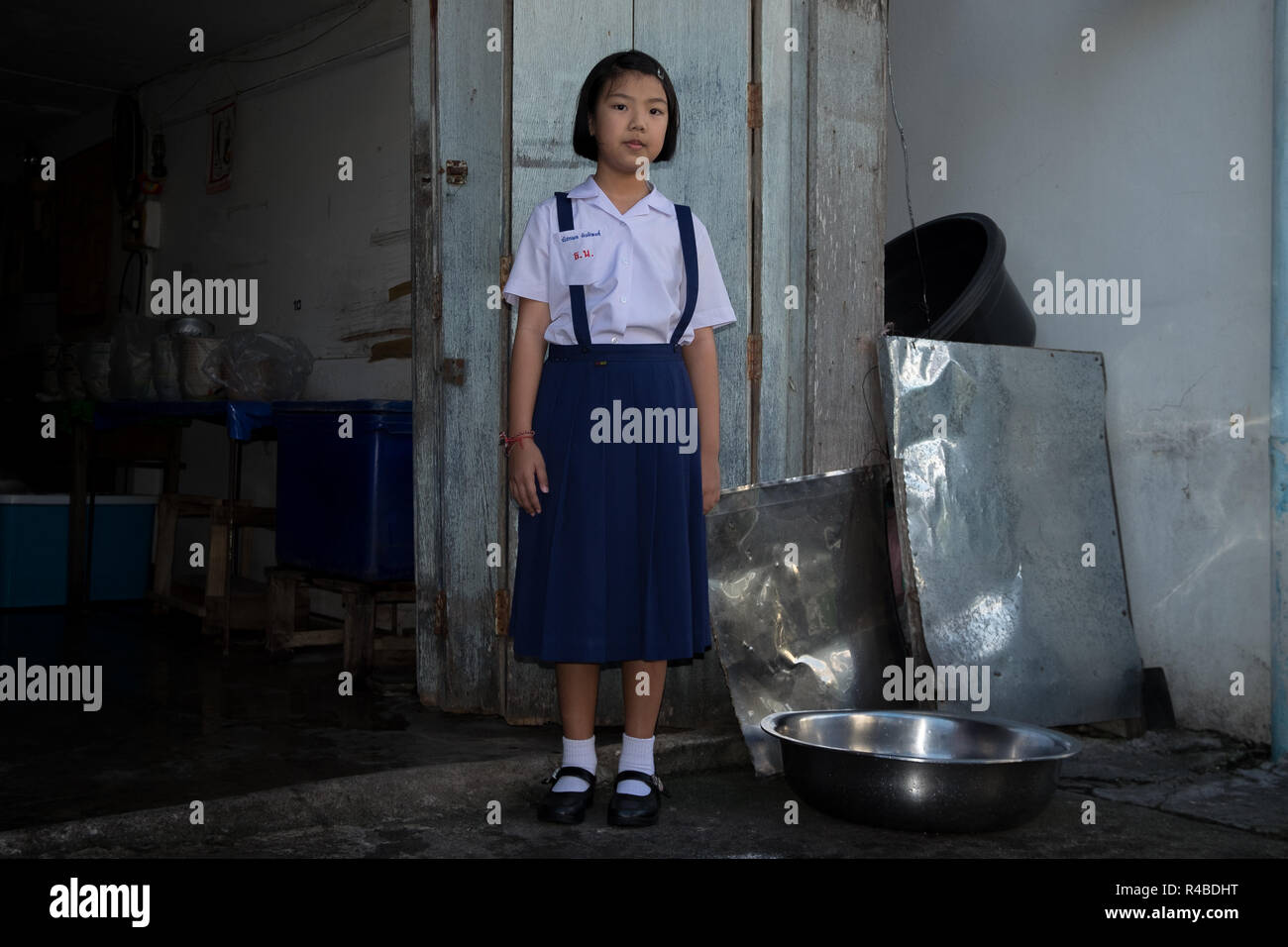 Un schoolgirl pone al di fuori di un negozio di alimentari in Hat Yai, Thailandia. Foto Stock