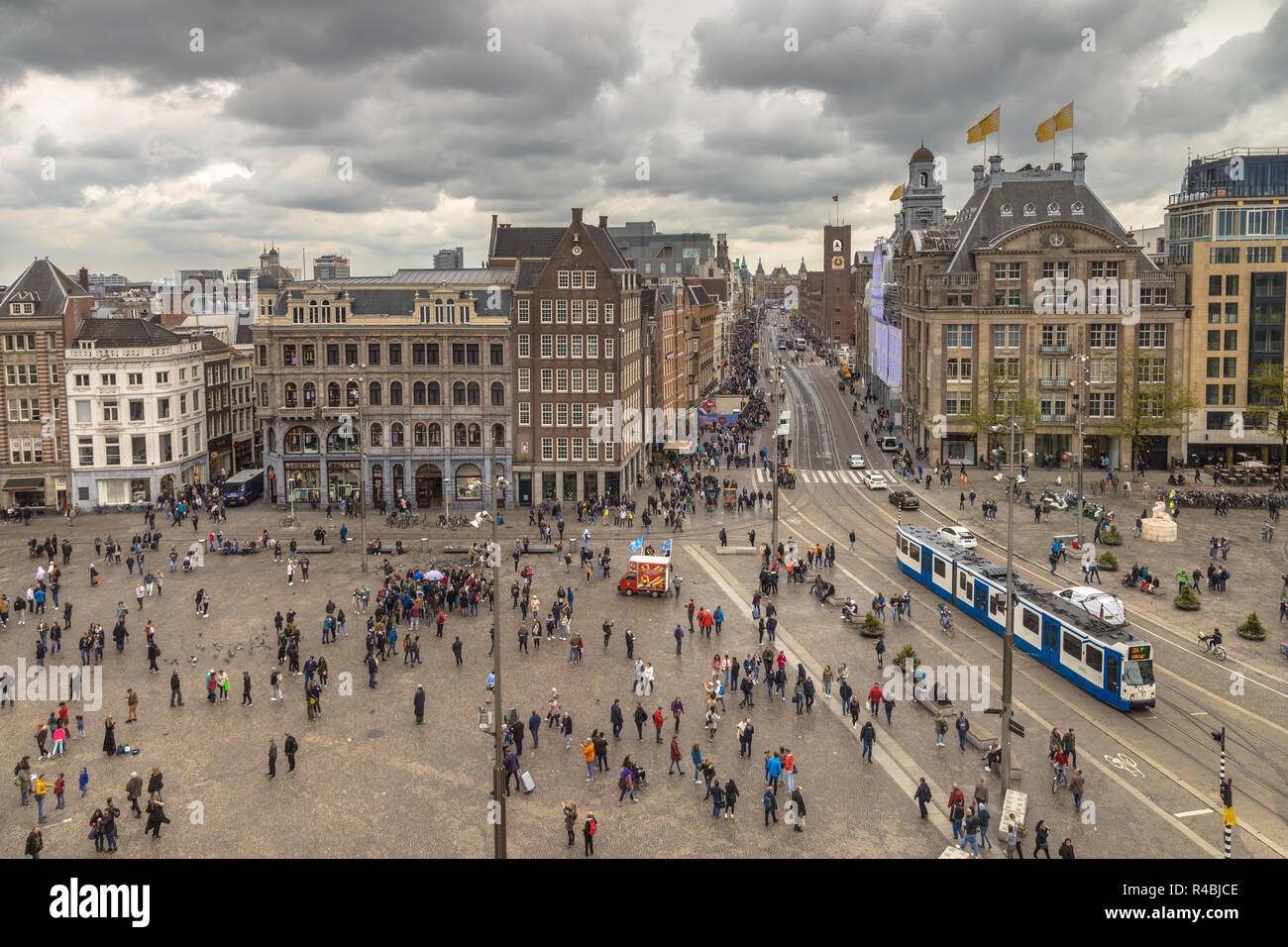 Amsterdam Piazza Dam vista con molti tousits e tram sul tipico olandese giorno nuvoloso Foto Stock
