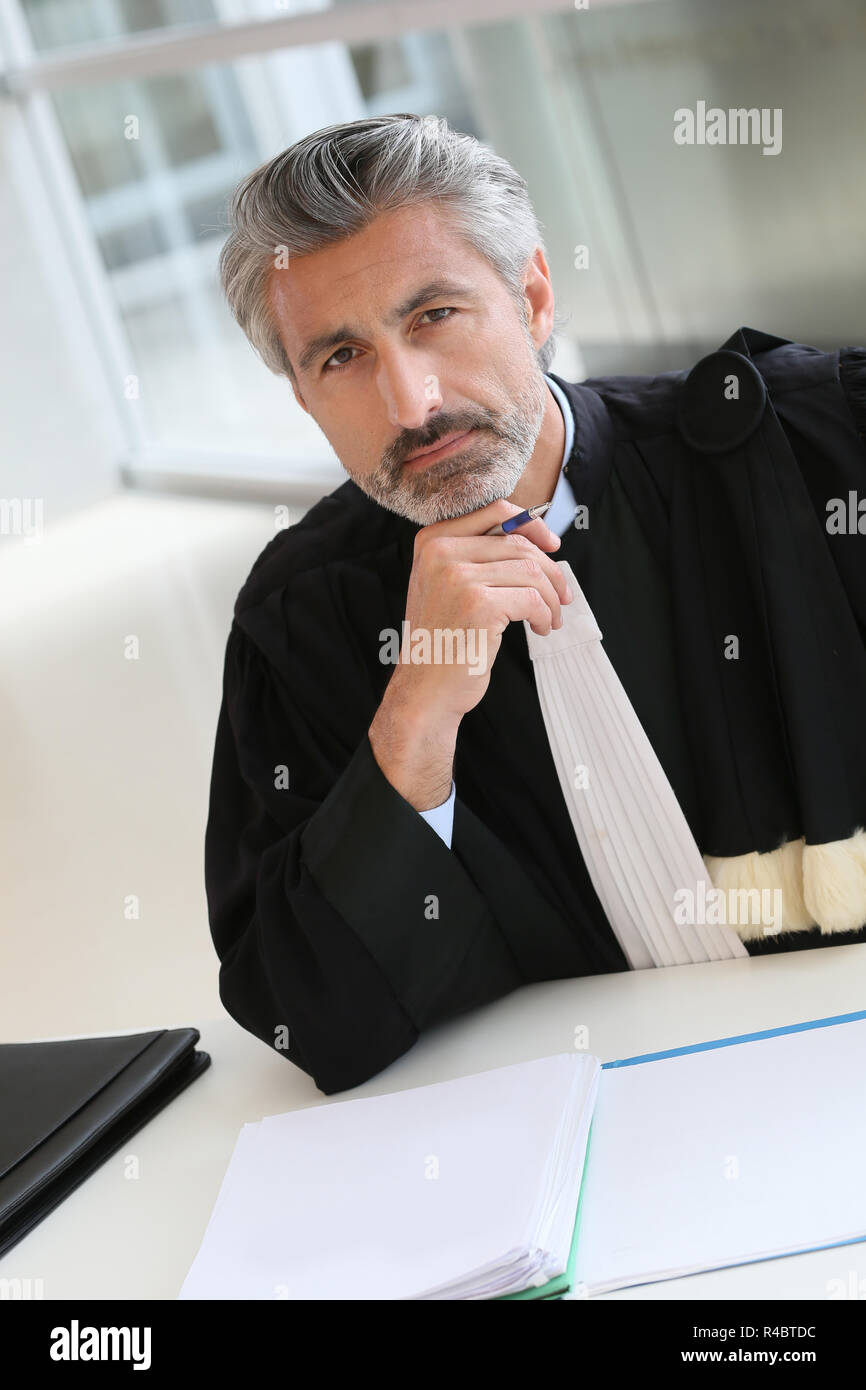 Avvocato maturo lavorando sulla relazione di giudizio Foto Stock