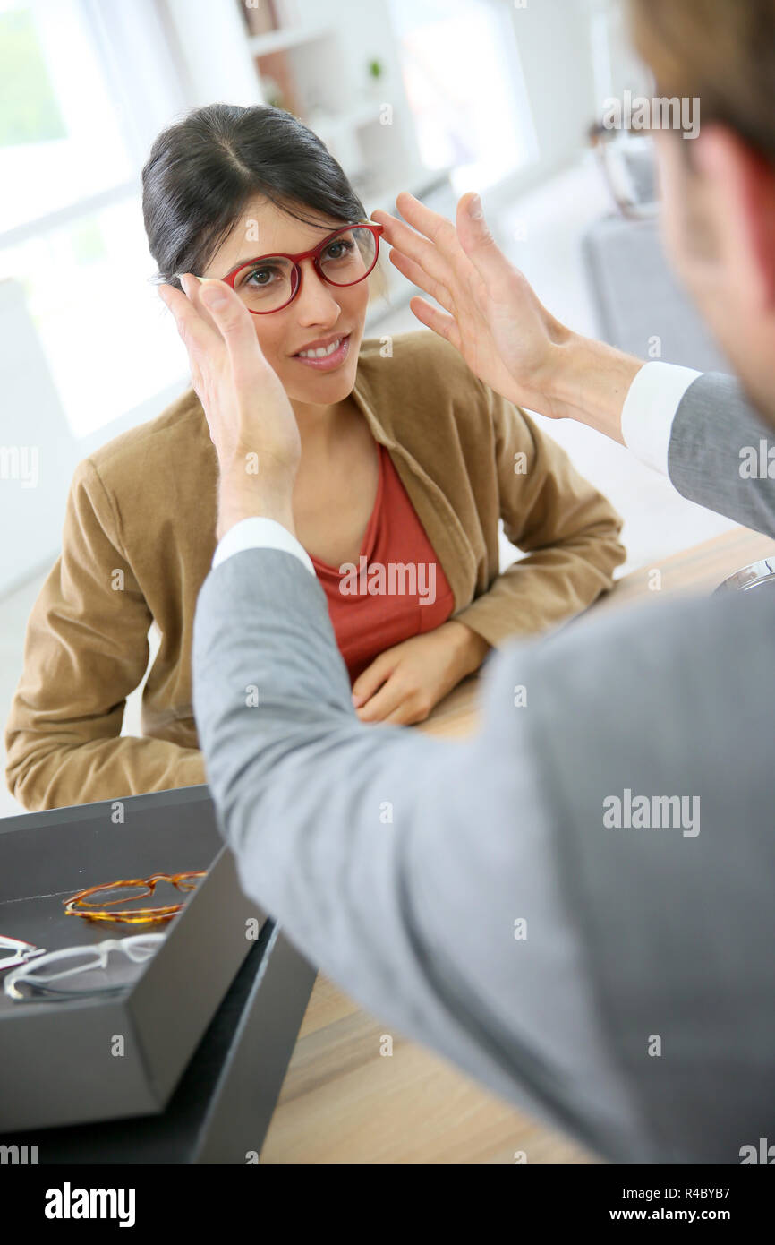 Ottico della sperimentazione di nuovi occhiali sulla donna Foto Stock