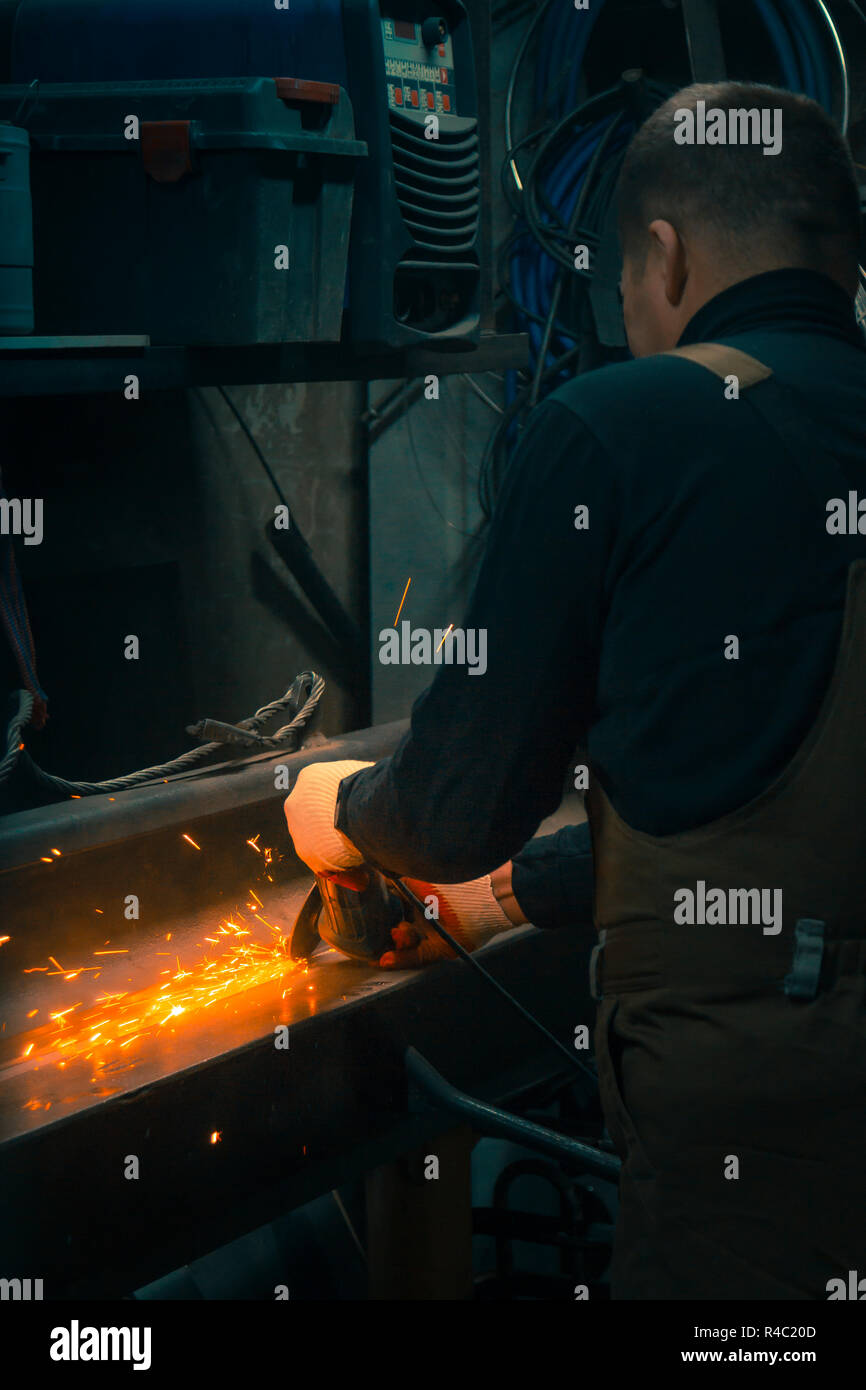 Ritratto di un fabbro macinino di guanti durante il lavoro Foto Stock