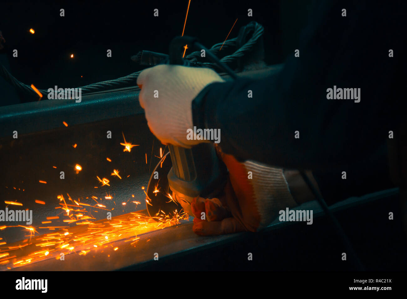 Le mani di un macinino meccanico in guanti durante il lavoro Foto Stock