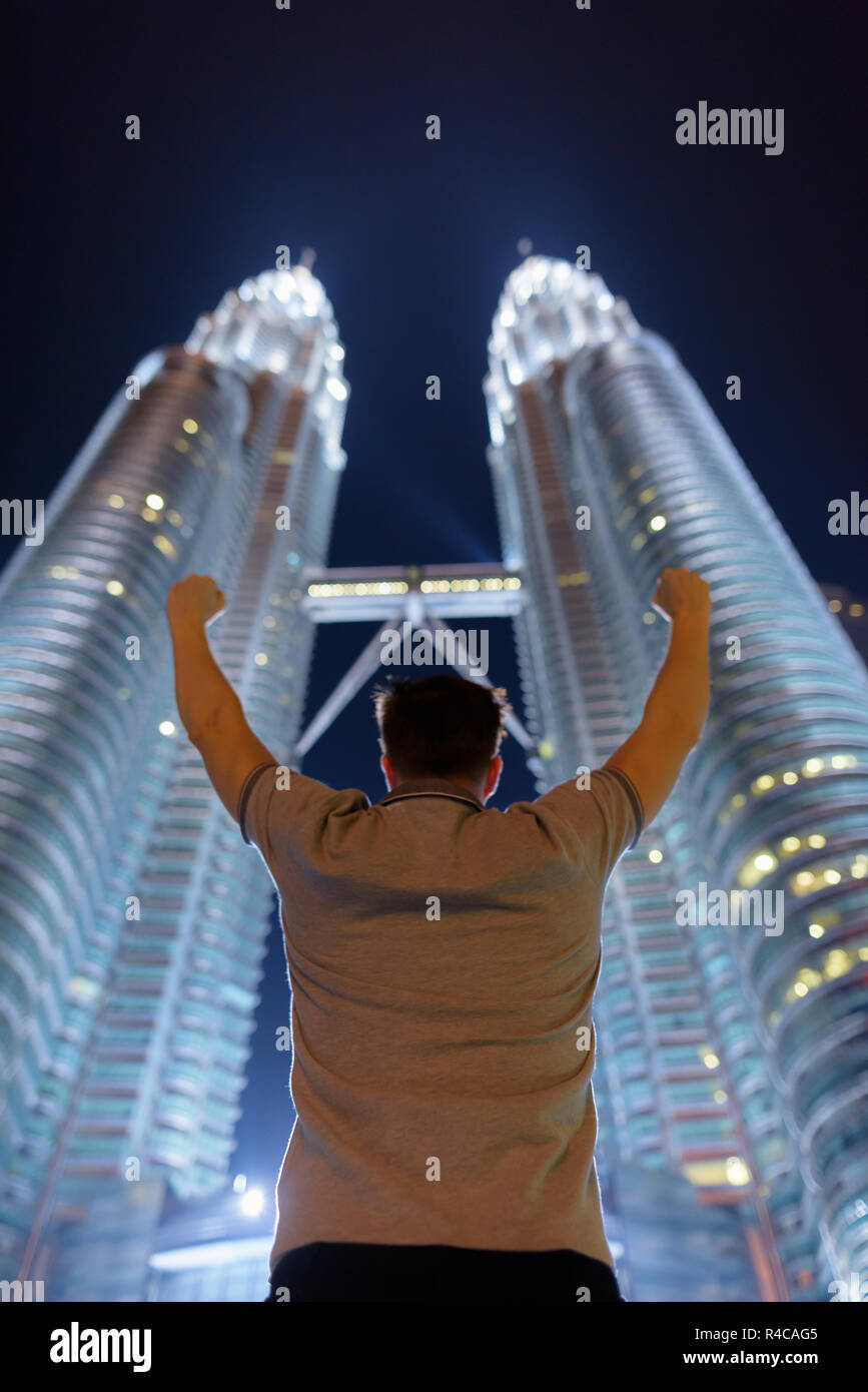 Giovane uomo bello contro la vista delle Petronas Twin Towers a n Foto Stock