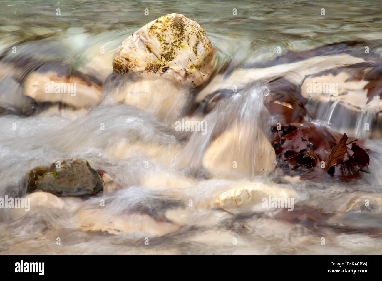 Ruscello di montagna che scorre tra le pietre e salutato marrone con foglie di autunno Grecia Foto Stock