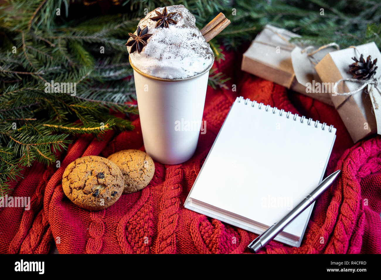Tazza di caffè con panna montata e cannella, avena cookies, vuoto note sull albero di natale e maglione rosso sfondo. Il frappuccino caffè. Concetto di Foto Stock