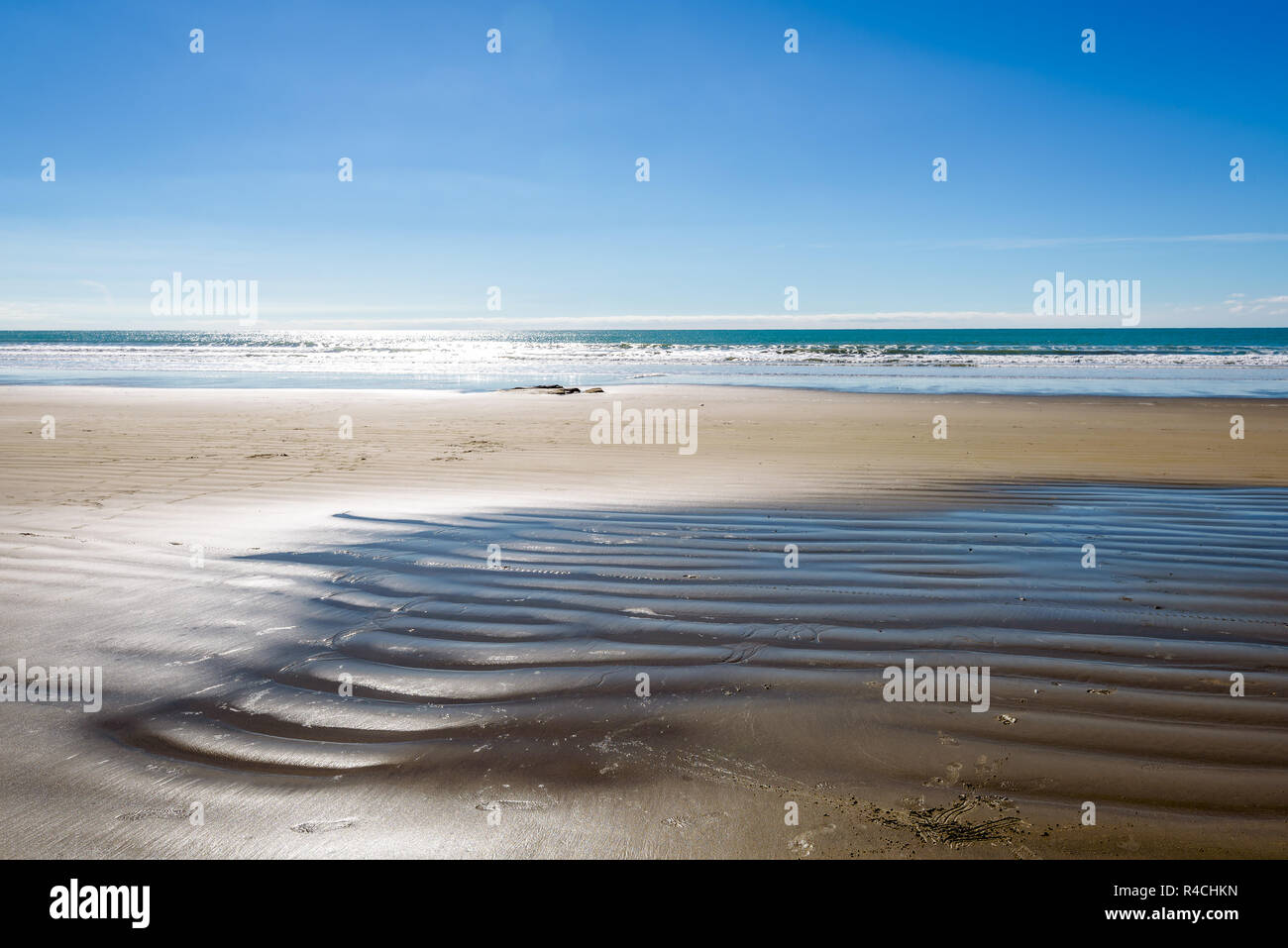 Bella deserta spiaggia vuota paesaggio con la riflessione del cielo sull'acqua. Moeraki Boulders sulla spiaggia Koekohe, costa di Otago, Nuova Zelanda. Foto Stock