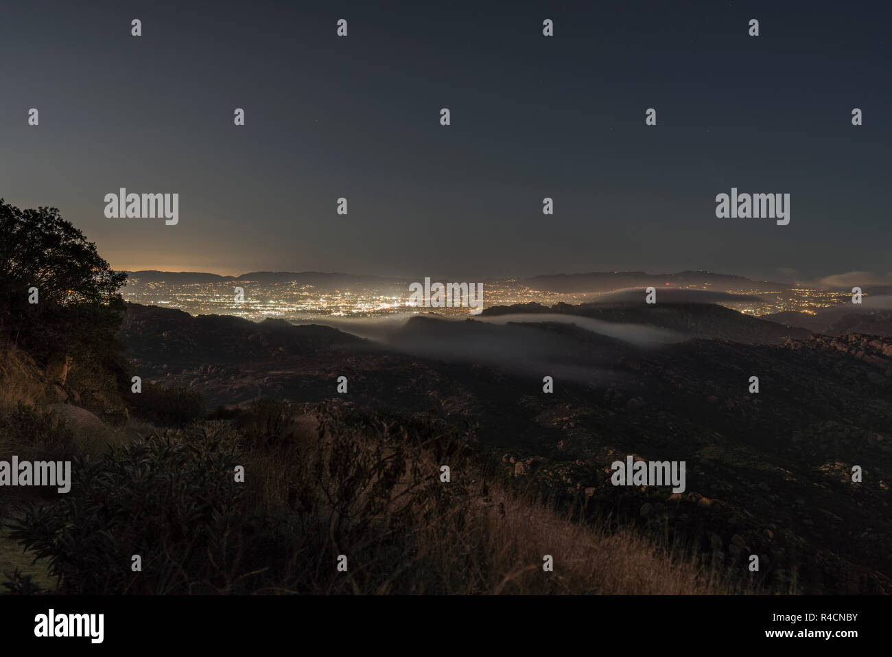 Vista Collina di nebbia versando sopra la Santa Susana passano nella valle di San Fernando zona di Los Angeles, California. Girato dal picco roccioso Mountain Park Foto Stock