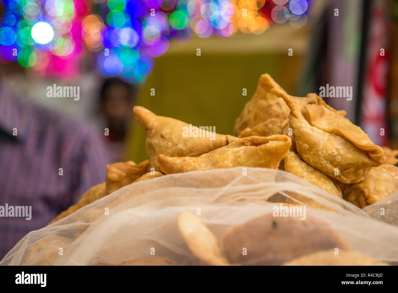 Indian street food venditore vendere fresco Samosa e kachoris,una varietà popolare in una strada trafficata di Delhi Foto Stock