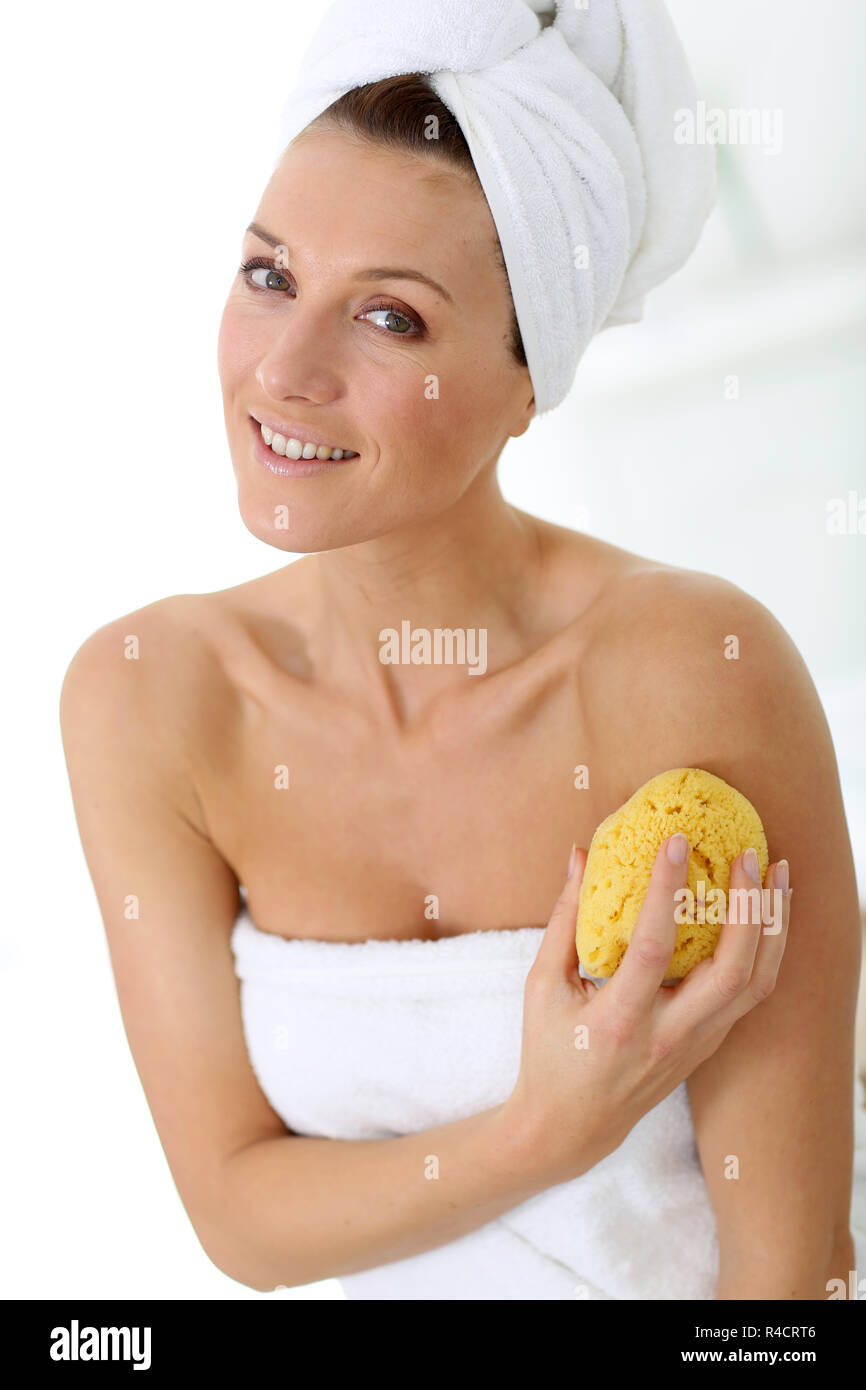 Donna attraente in bagno con spugna Foto Stock