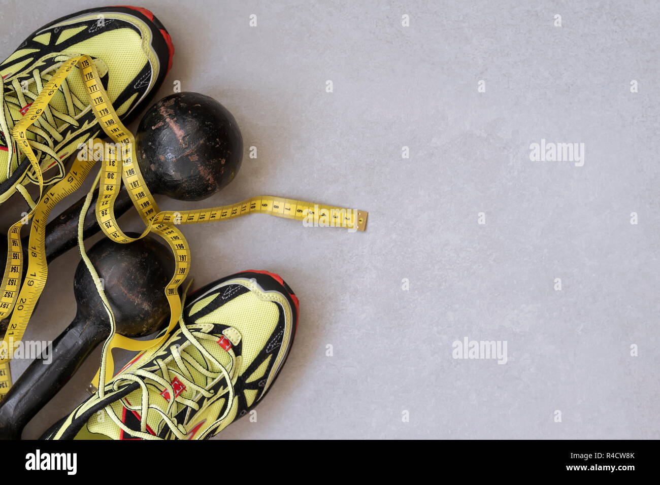 Sneakers, vecchi pesi e nastro di misurazione, vista dall'alto, il concetto di uno stile di vita sano. Sfondo di sport, spazio di copia Foto Stock
