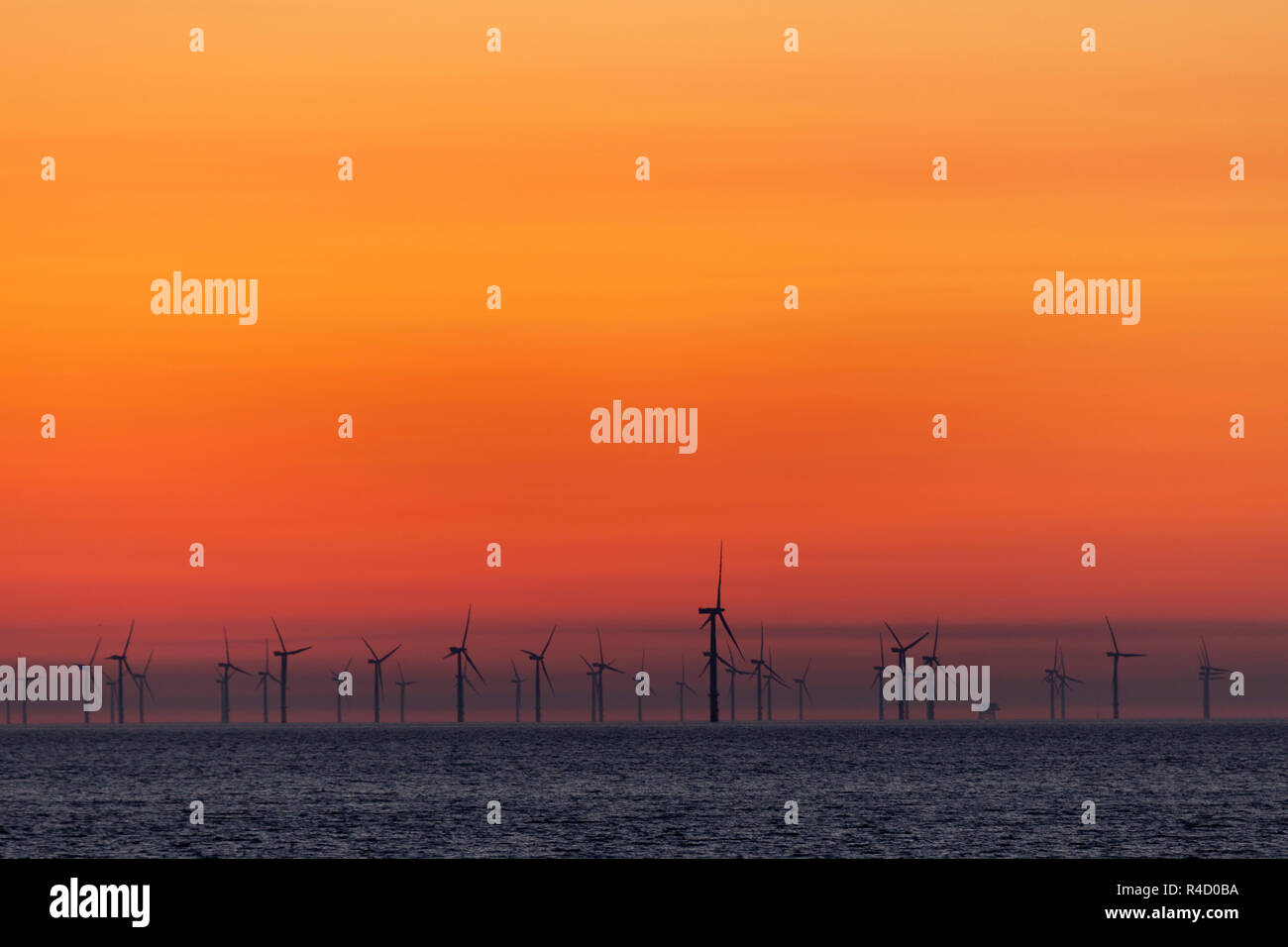 Sulle turbine eoliche offshore all'alba a Colwyn Bay sulla costa settentrionale del Galles Foto Stock