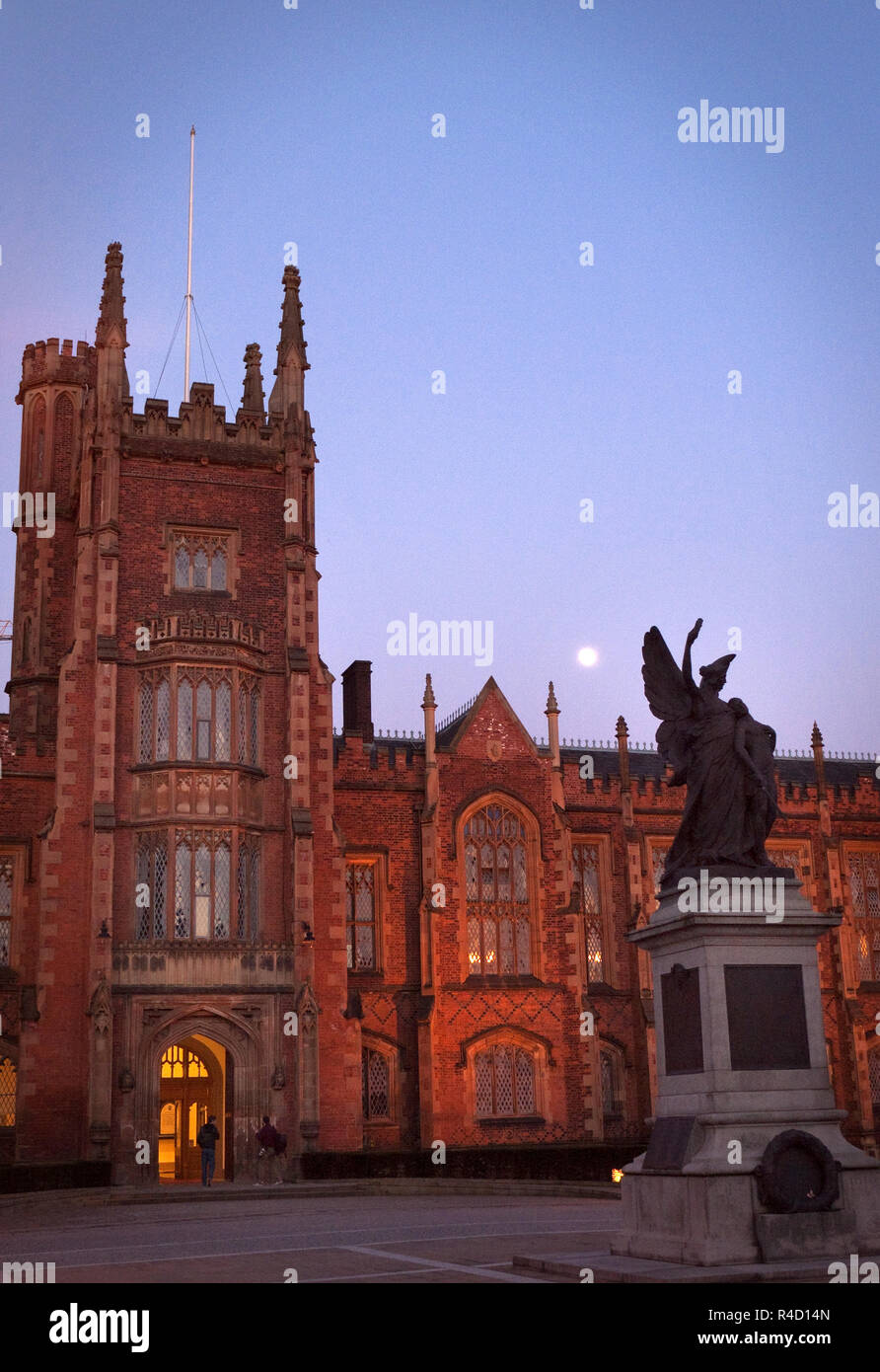 La luna oltre il Memoriale di guerra e la facciata dell'edificio Lanyon, Queen's University di Belfast, Irlanda del Nord di notte. Foto Stock