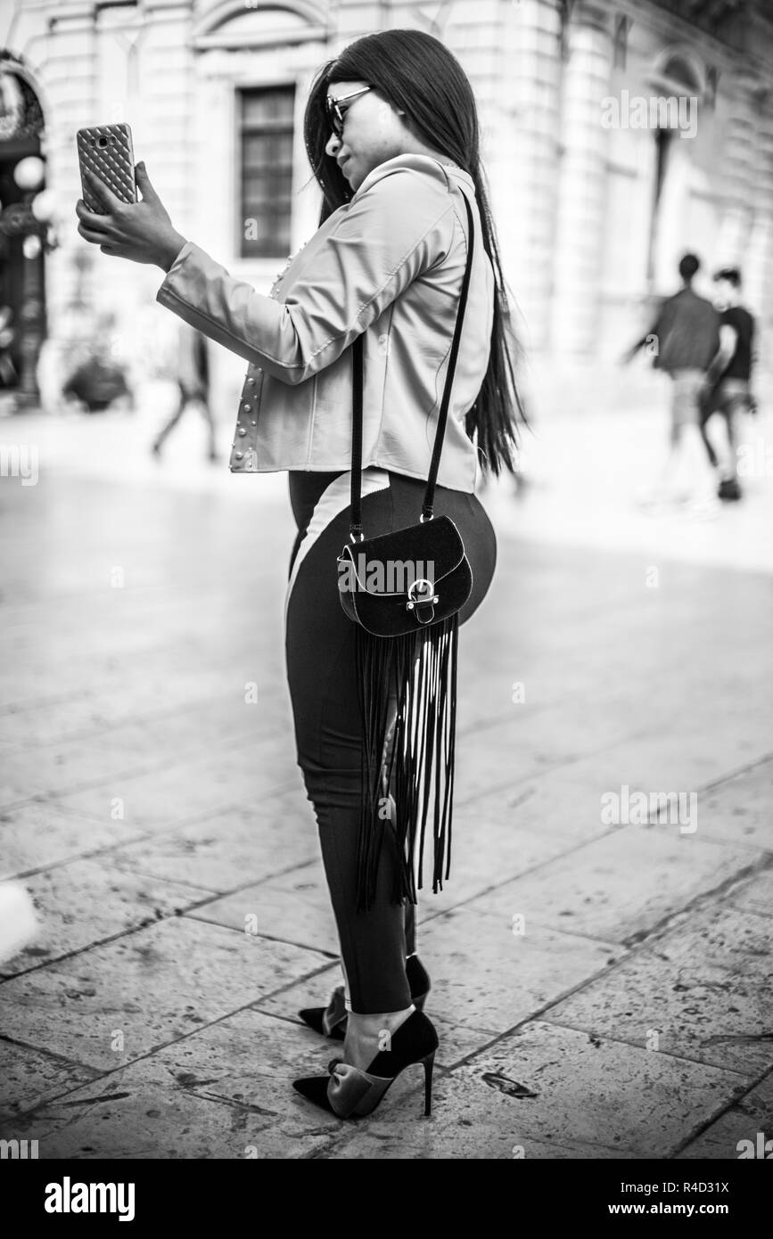 Una donna fanno selfie nella strada SIracusy, Europa, Italia, Europa. Foto Stock