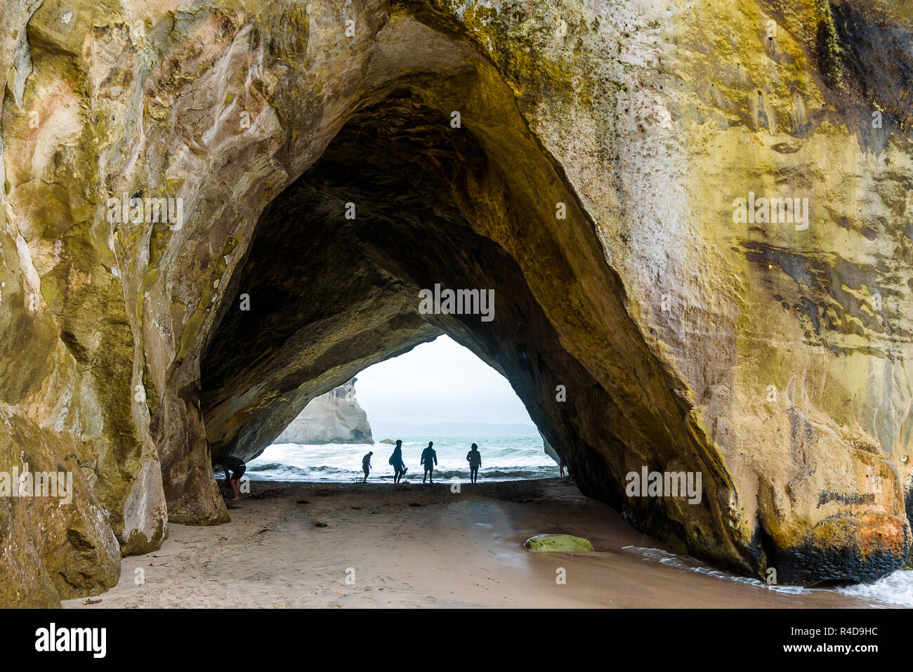 Arco di roccia in Te Whanganui-A-Hei (Cove della cattedrale) riserva marina, Nuova Zelanda. Silhouette di persone vicino al litorale. Foto Stock