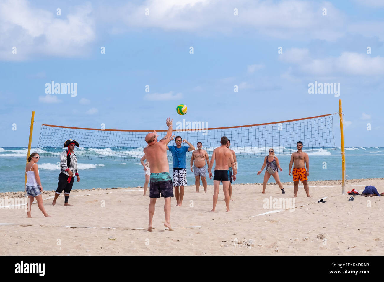 Tourist si impegnano in una partita di pallavolo sulla spiaggia a Playa Jibacoa a Cuba. Foto Stock