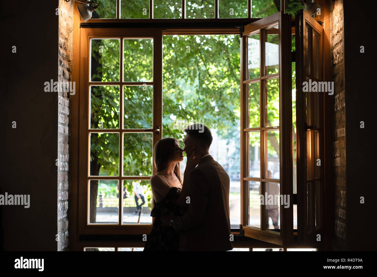 Coppia giovane in amore in piedi dalla finestra Foto Stock