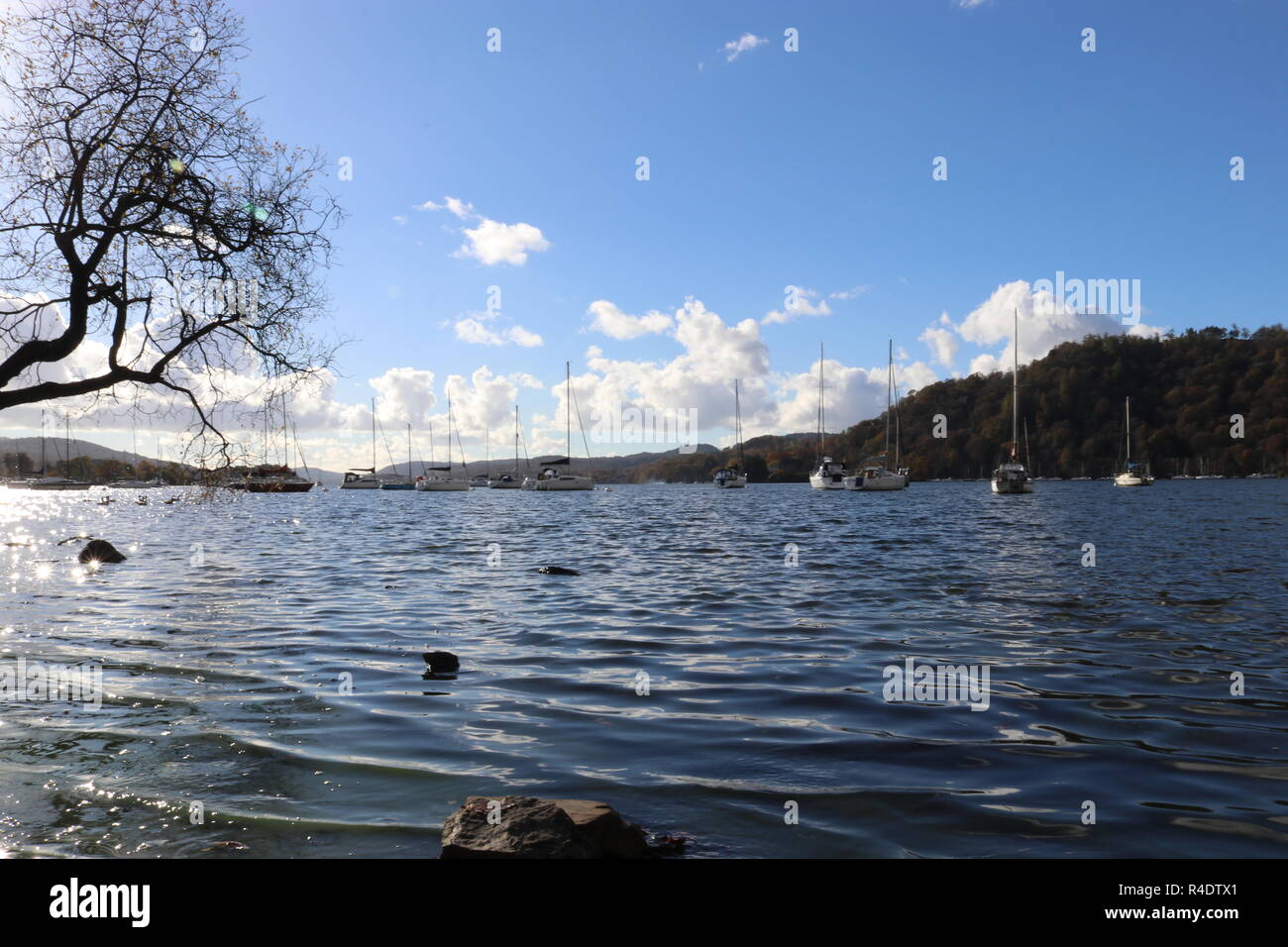 Lago di Windermere come vedere dalle banche di Bowness-on-Windermere su un soleggiato inverni giorno con barche ormeggiate. Lake District, Inghilterra, Regno Unito. Foto Stock