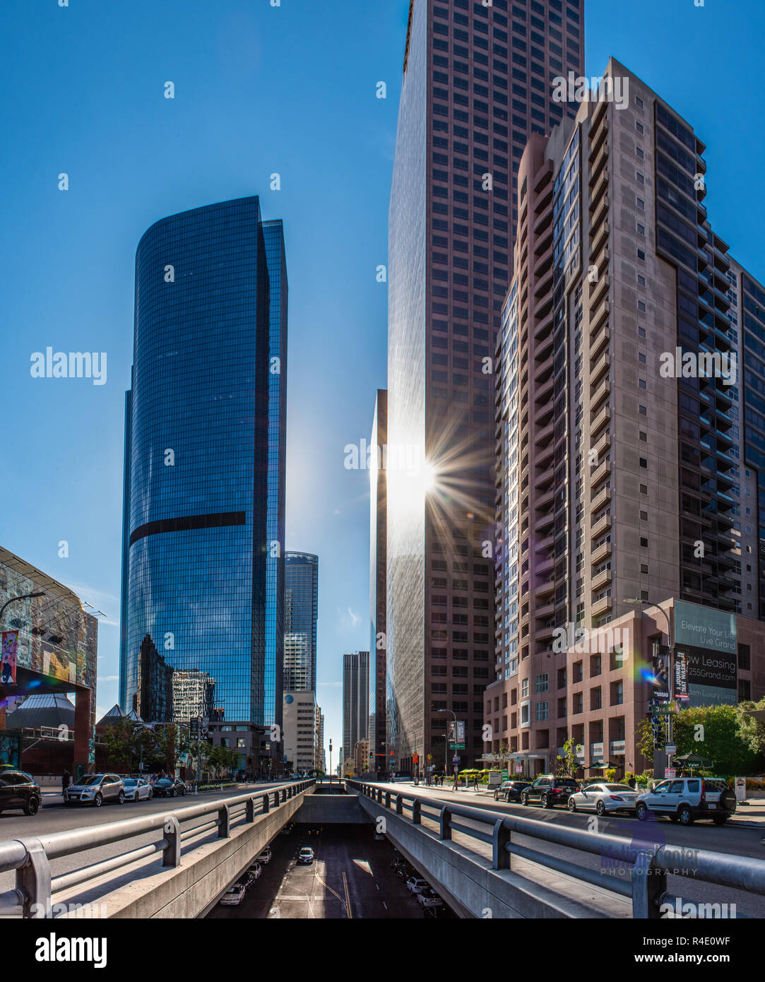 Il contrasto degli alti palazzi lungo il Grand Avenue nel centro di Los Angeles con il livello inferiore strade di superficie come sun riflette off majectic facciate su Foto Stock