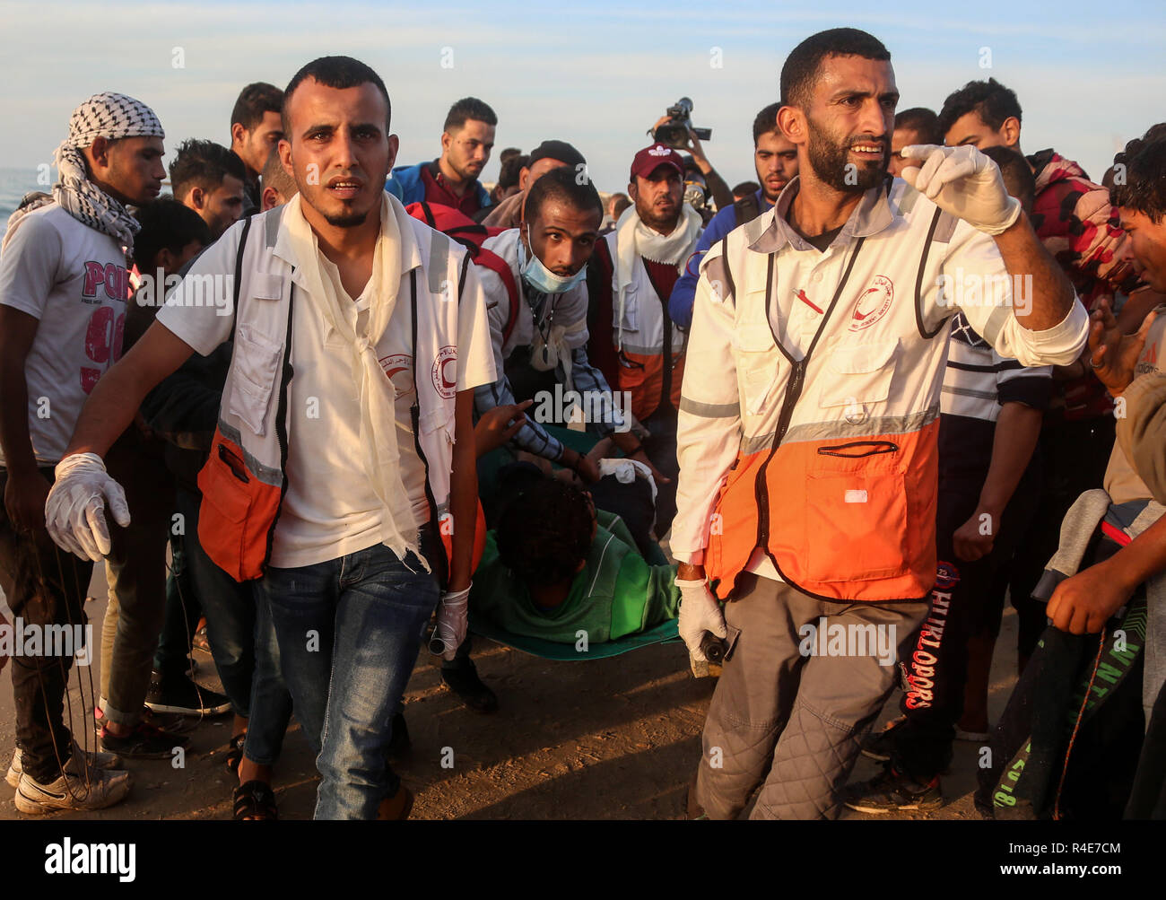 La striscia di Gaza. 26 Nov, 2018. I medici palestinesi portano un uomo ferito durante gli scontri con le truppe israeliane nei pressi del confine marittimo con Israele, nel nord della Striscia di Gaza, nov. 26, 2018. Almeno tre palestinesi sono stati feriti il lunedì e decine subito soffocamento dopo inalazione di gas lacrimogeni in scontri tra dimostranti palestinesi e soldati israeliani nel nord della Striscia di Gaza, i medici hanno detto. Credito: Xinhua/Alamy Live News Foto Stock