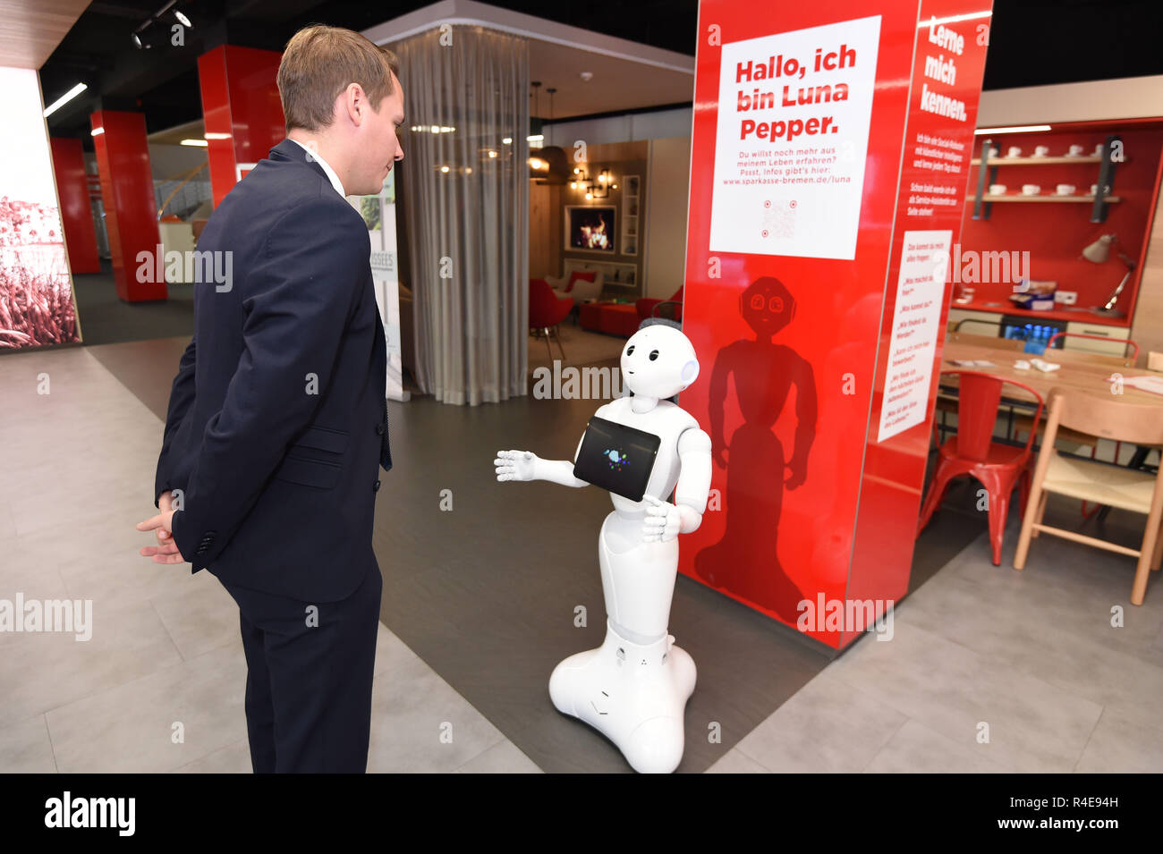 Bremen, Germania. Xvi Nov, 2018. Alexander Löde, capo del distretto ramo della Sparkasse Bremen-Neustadt, parla al robot 'Luna Pepe'. Il robot dovrebbe accogliere i clienti, il loro supporto e chiacchierare un po' con loro. Credito: Carmen Jaspersen/dpa/Alamy Live News Foto Stock