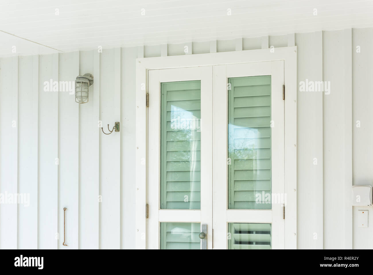 Verde pastello colorato uragano persiane aperte architettura esterna della casa in Florida beach home appartamento edificio durante il giorno ingresso, glas Foto Stock