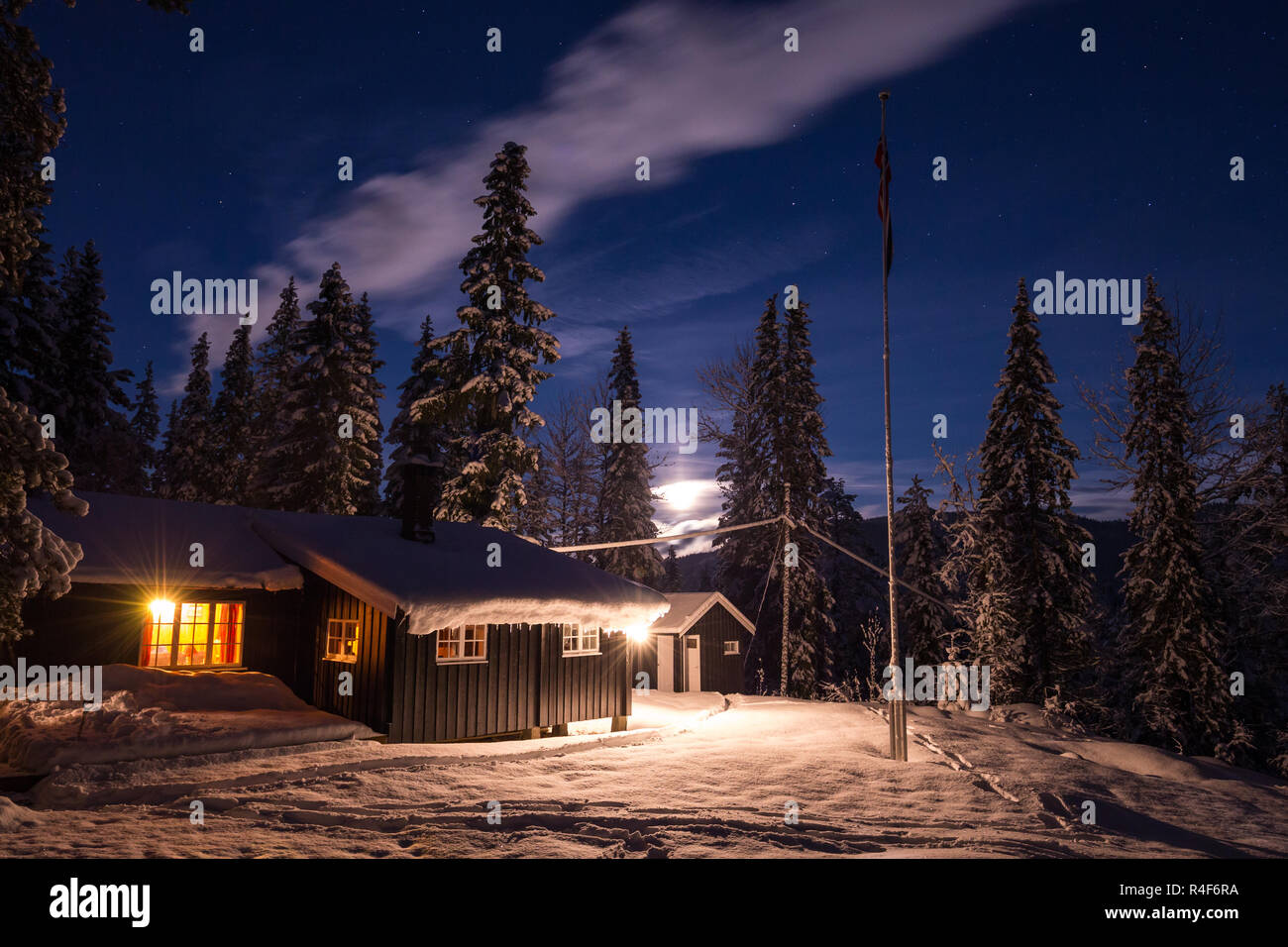 Foresta cabina scandinavo nel bosco innevato. Inverno in Norvegia. Notte tempo. Foto Stock