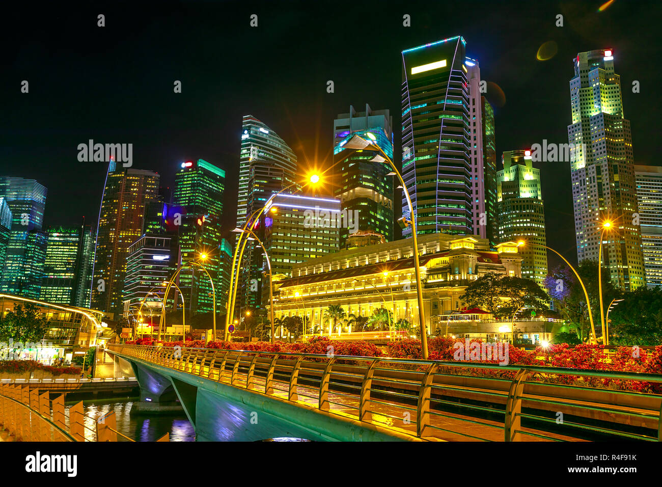 Singapore skyline del quartiere degli affari e il ponte pedonale in marina bay promenade. Singapore di notte le luci della Marina Bay. Foto Stock