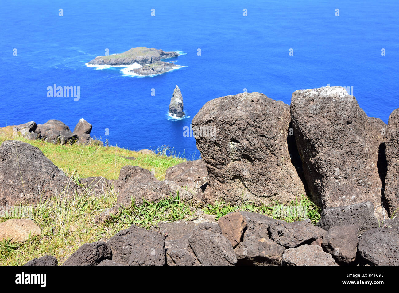 Birdman petroglyph culto in Orongo, Isola di Pasqua con Motu Iti e Motu Nui in background. Foto Stock