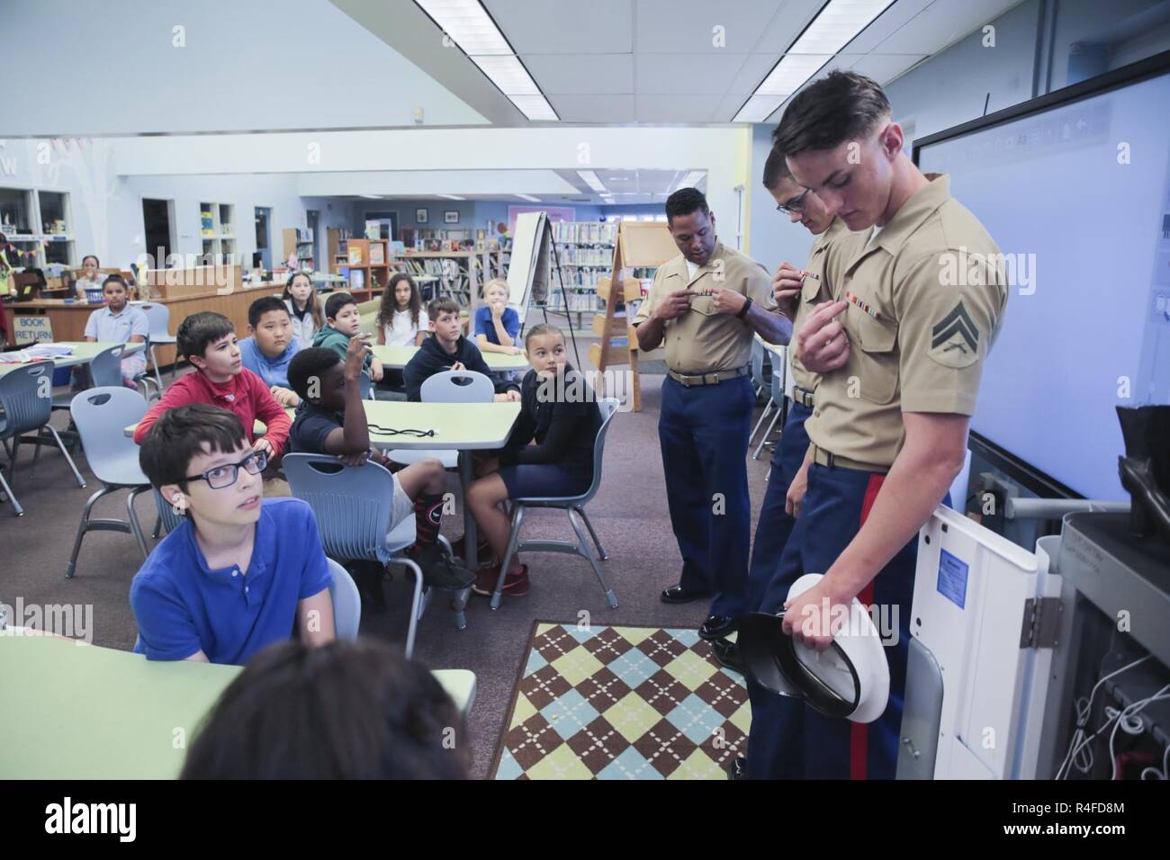 DAVIE, Fla. -- Cpl. Giacobbe Tatam, estrema destra, risponde alle domande circa il Marine Corps uniforme mentre visitano Silver Ridge scuola elementare in Davie, Fl., 2 maggio 2017. Marines con 3° Battaglione, 2° Reggimento marino ha visitato le scuole come parte delle relazioni comunitarie sforzi durante la settimana della flotta Port Everglades. Tatam è un anti-serbatoio missileman con 3/2. Foto Stock