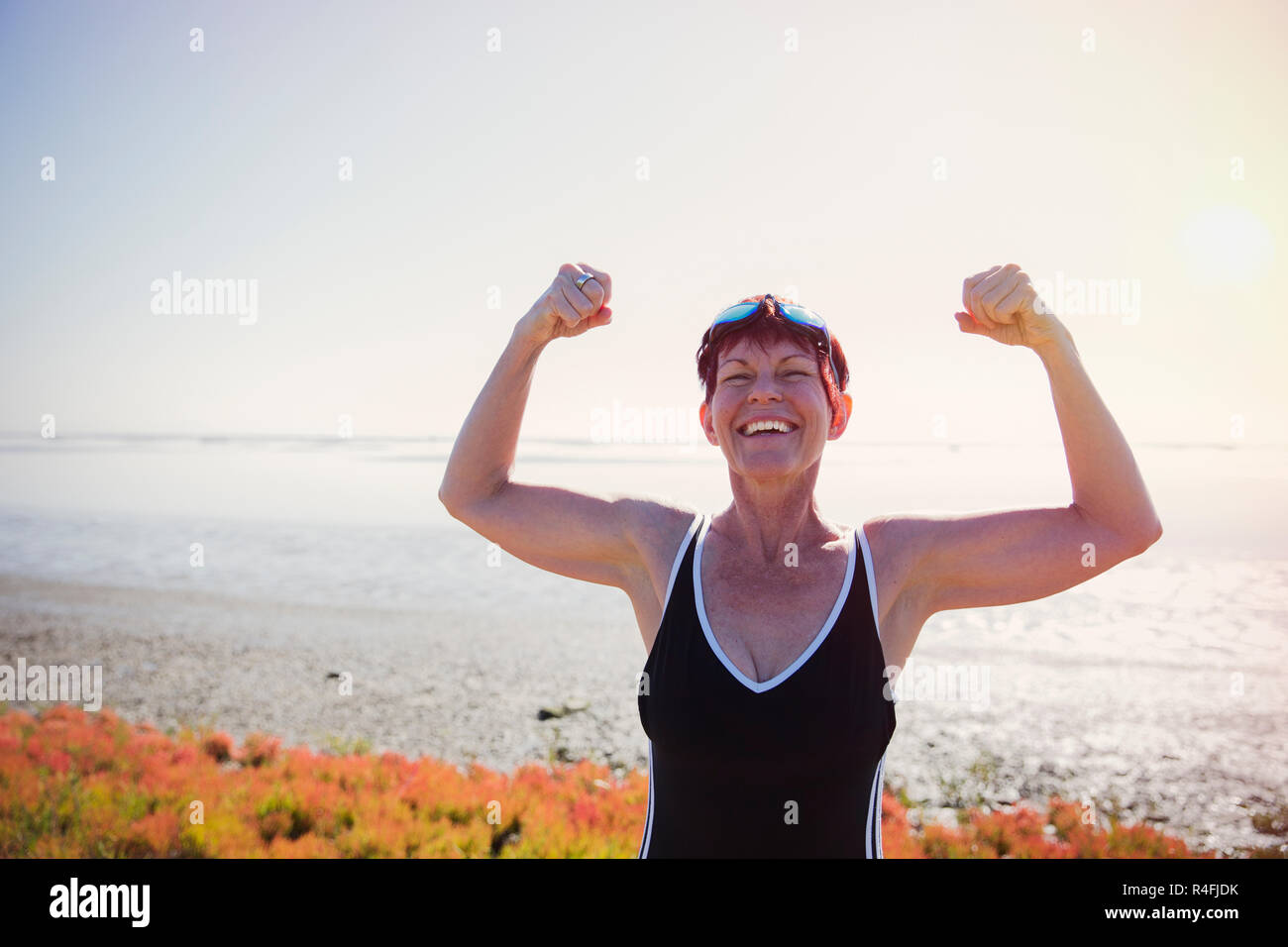 Vecchia donna flettendo i suoi muscoli Outdoor Foto Stock