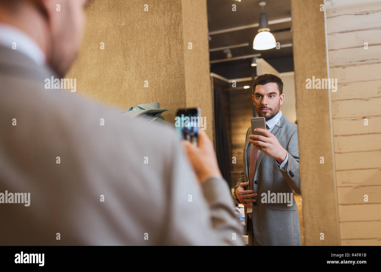 Uomo in tuta prendendo selfie specchio al negozio di abbigliamento Foto  stock - Alamy
