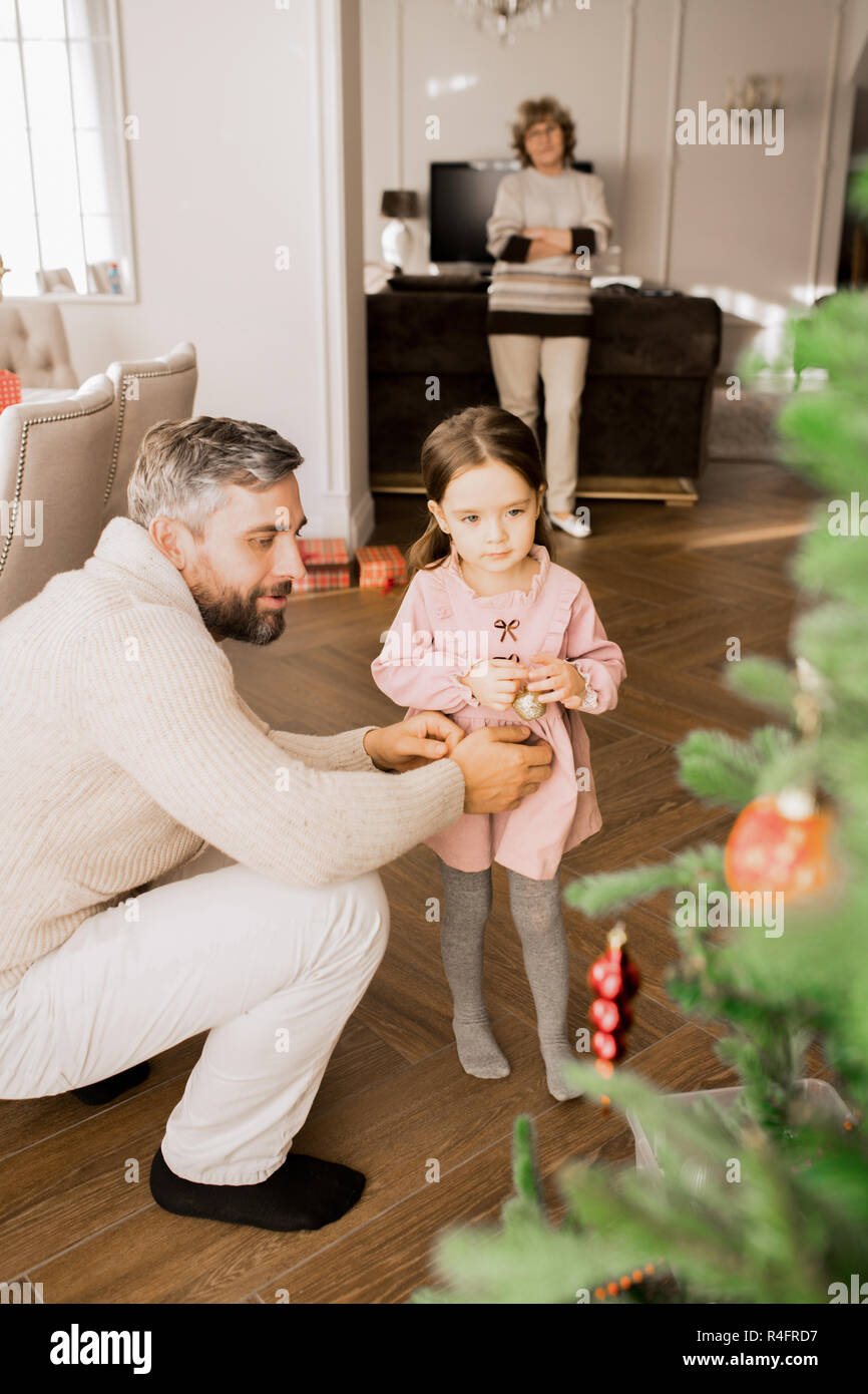 Bambina decorare albero di Natale Foto Stock