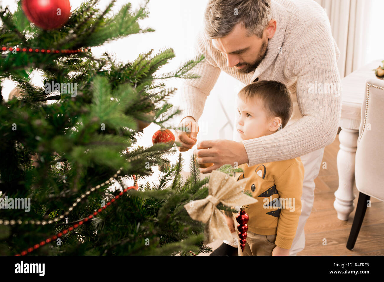 Little Boy decorare albero di Natale Foto Stock