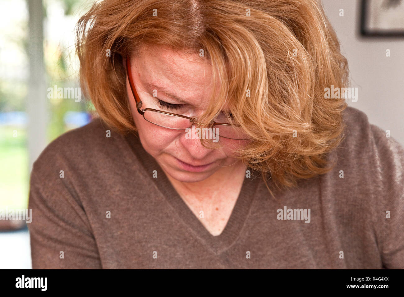 Donna con i capelli rossi sta leggendo il giornale Foto Stock