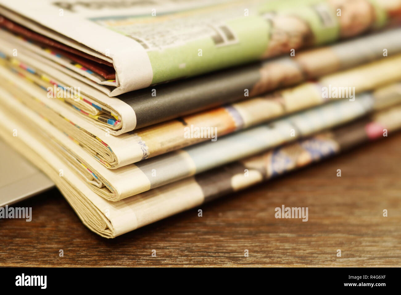 Pila di mattina freschi quotidiani sul tavolo in ufficio. Ultime notizie finanziarie ed economiche nel quotidiano. Le pagine con i dati. Piegato e riviste impilati Foto Stock