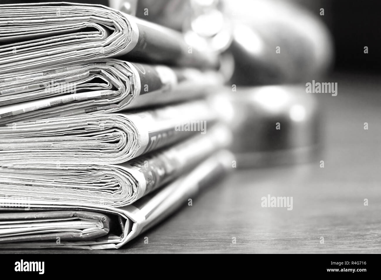 Pila di mattina freschi quotidiani sul tavolo in ufficio. Ultime notizie finanziarie ed economiche nel quotidiano. Le pagine con i dati. Piegato e riviste impilati Foto Stock