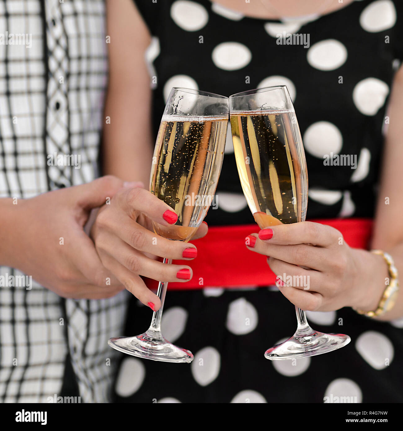Due bicchieri di champagne e mani. Giovane famiglia felice celebrare la  nuova data,buon compleanno,anniversario.giovane famiglia felice celebrare  la nuova data,buon compleanno,anniversario. Giovane celebra l'anniversario,  bevande champagne, è
