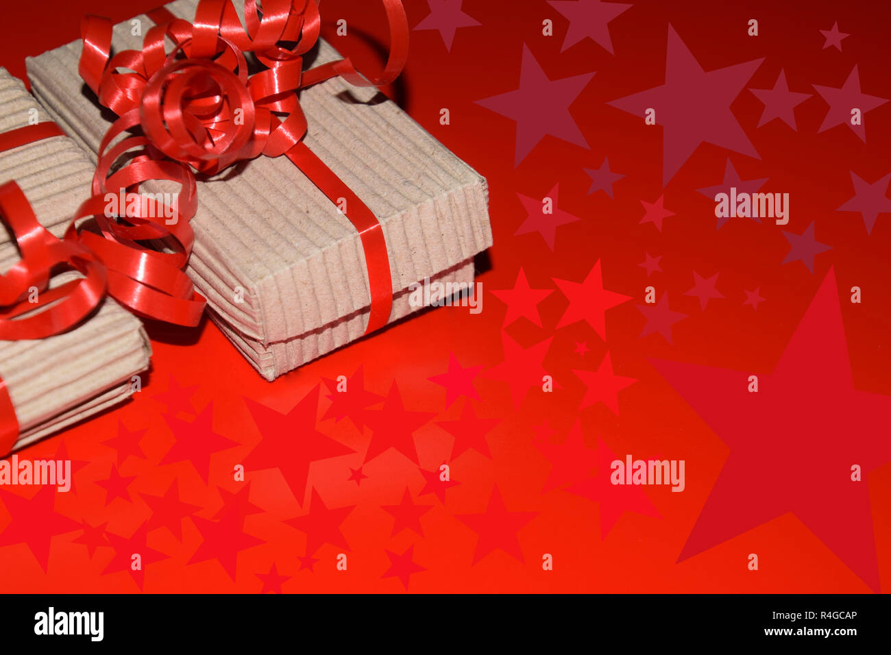Stella di simboli e di regali di natale con copia spazio, vista dall'alto della confezione regalo confezionate in imballaggi di cartone con nastro rosso sulla superficie rossa Foto Stock