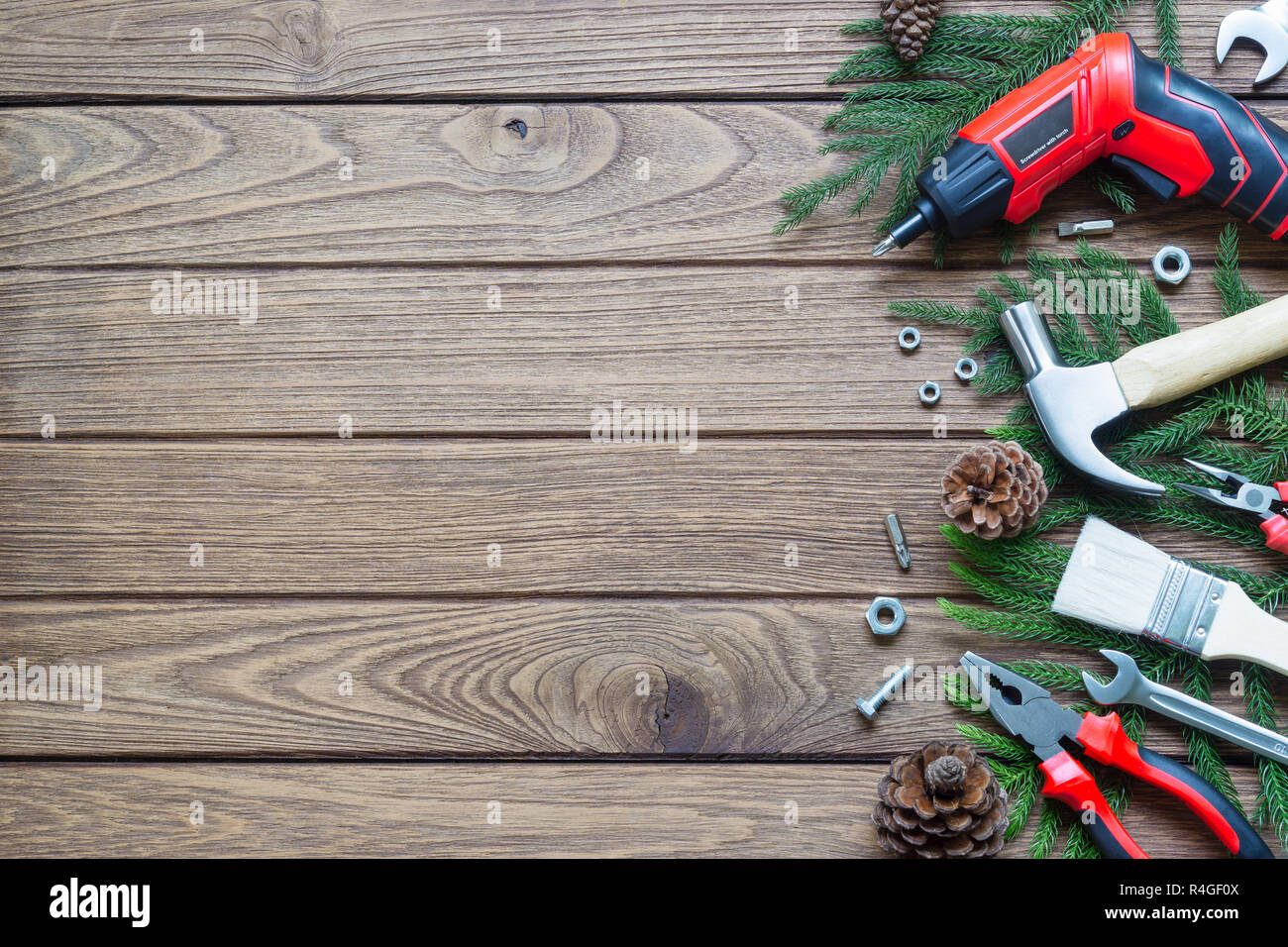 Buon Natale e felice anno nuovo a portata di mano strumenti di costruzione concetto di sfondo. Martello, chiavi, cacciaviti, pinze, spazzola di vernice, foglie di pino, pino Foto Stock